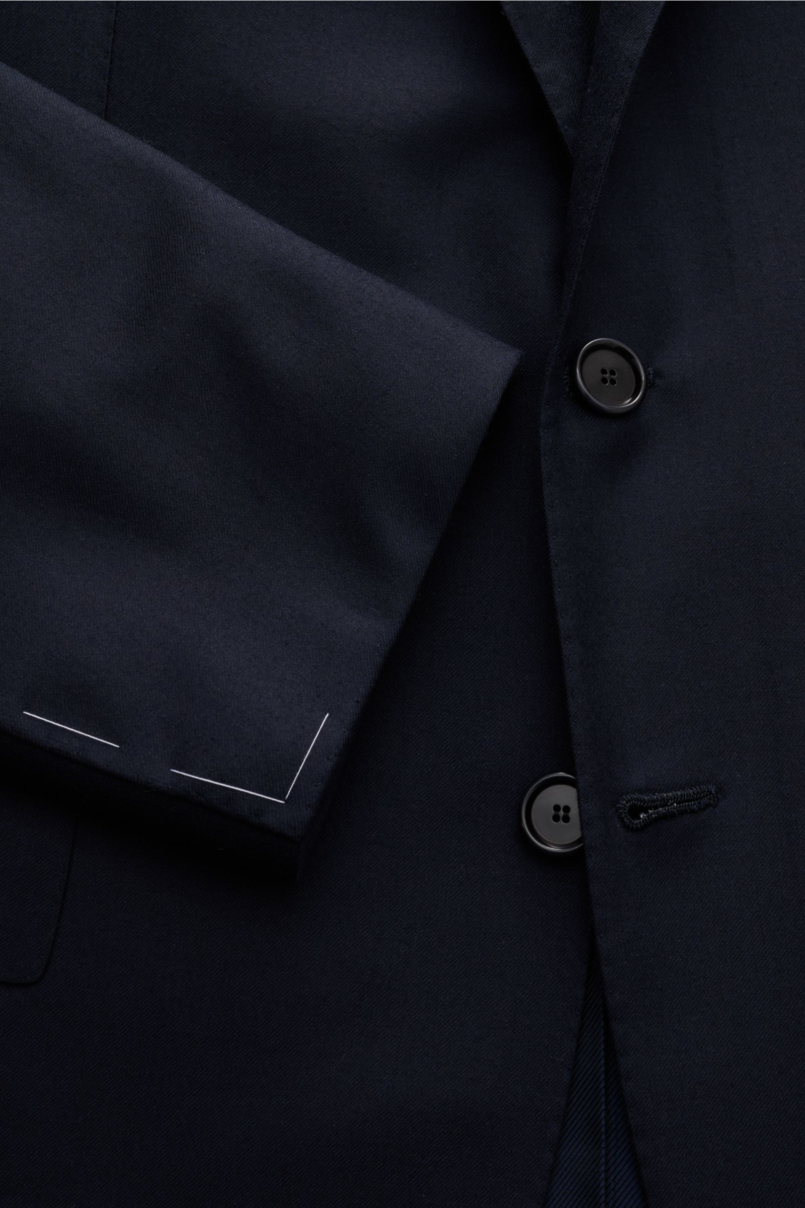 Close-up front view of the Cesare Attolini Anzug dark navy jacket sleeve and buttons, made from smooth Super 150'S wool with slim fit tailoring.