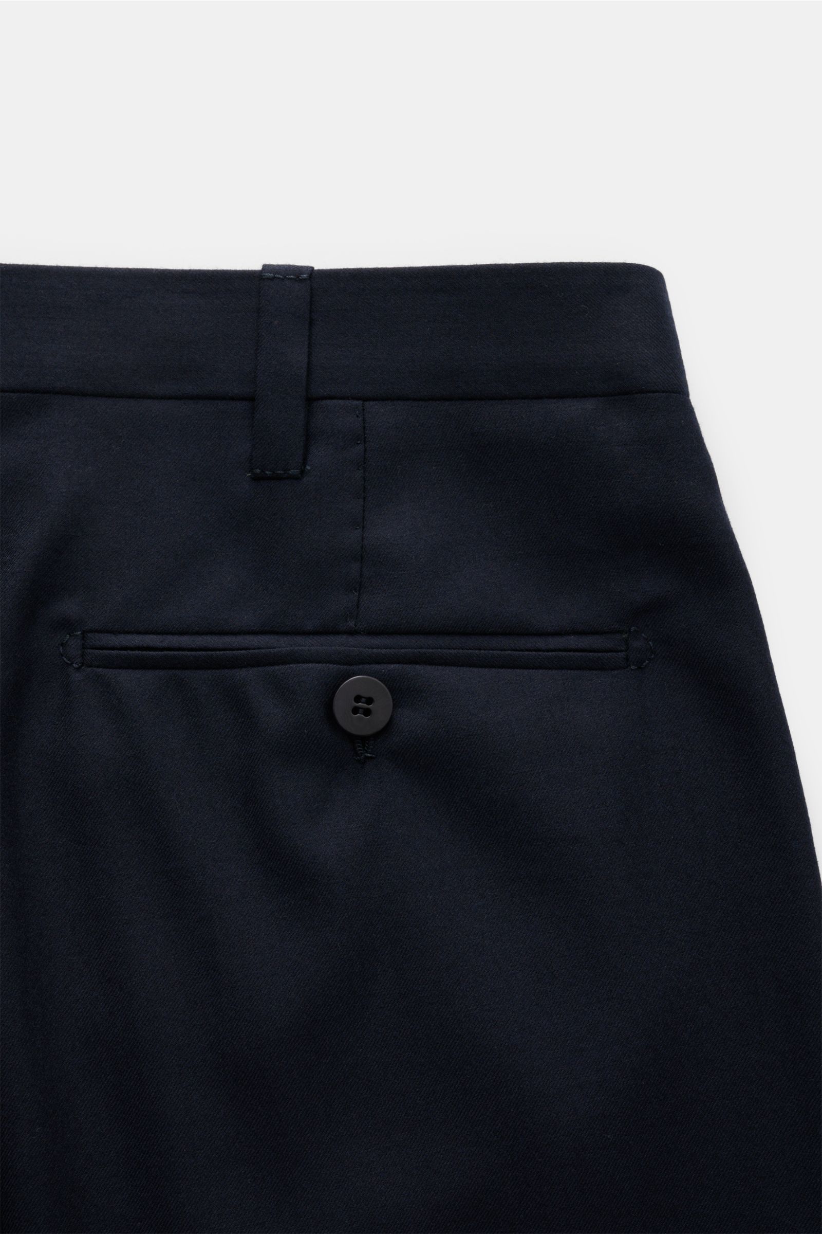 Dark navy Cesare Attolini Anzug pants shown from a close-up rear perspective, highlighting the buttoned back welt pocket and belt loop, made of pure Super 150'S wool with a smooth finish, slim fit, and tailored details including regular thigh width and sl