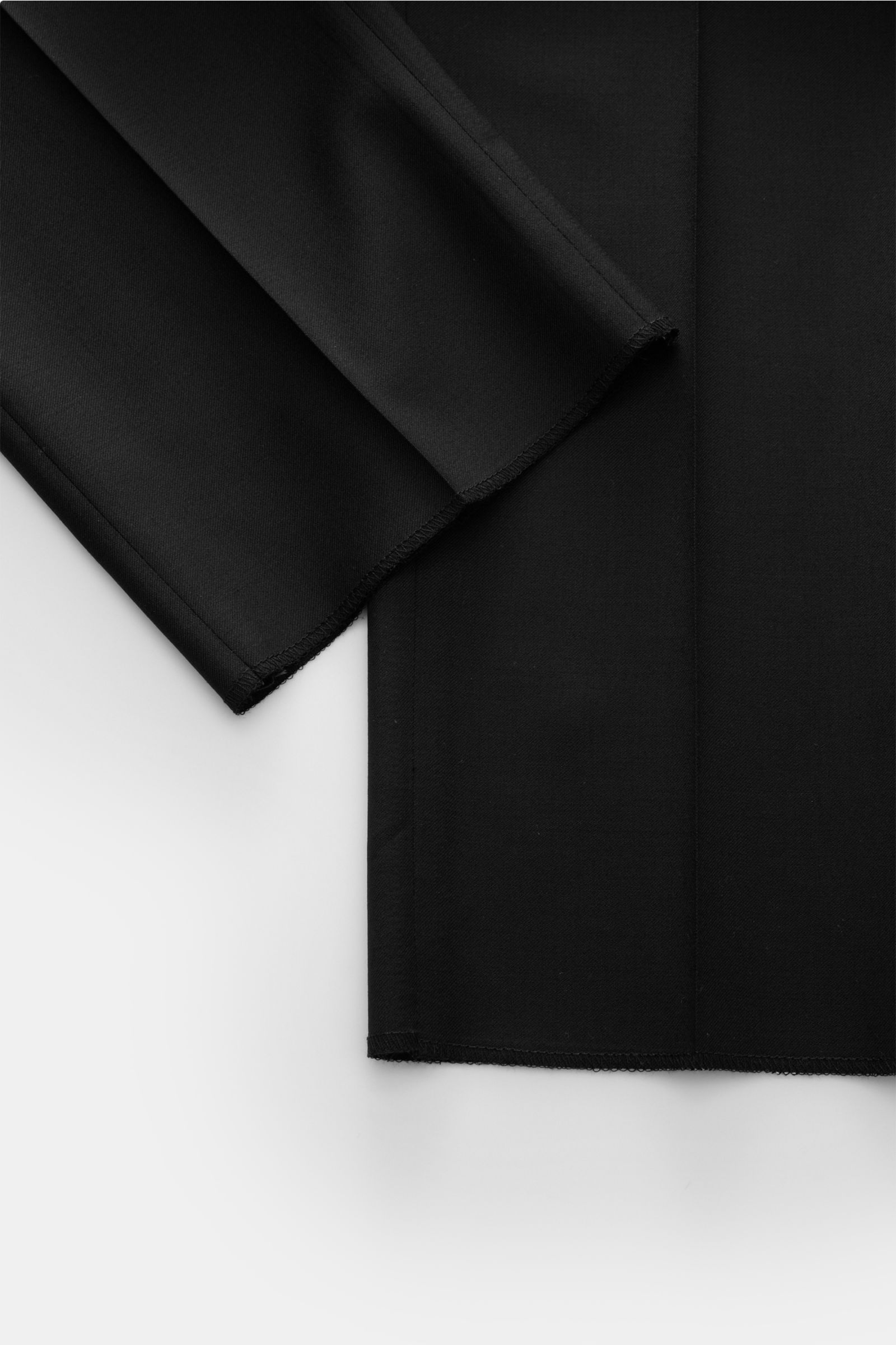 Black fabric close-up of the Tagliatore Anzug 'Vesuvio' schwarz, showing folded sleeves and hem from a top-down perspective. Zeitgenössisches Design trifft italienische Tradition aus dem Hause TAGLIATORE: Mit dem ebenso eleganten wie komfortablen, halb ge
