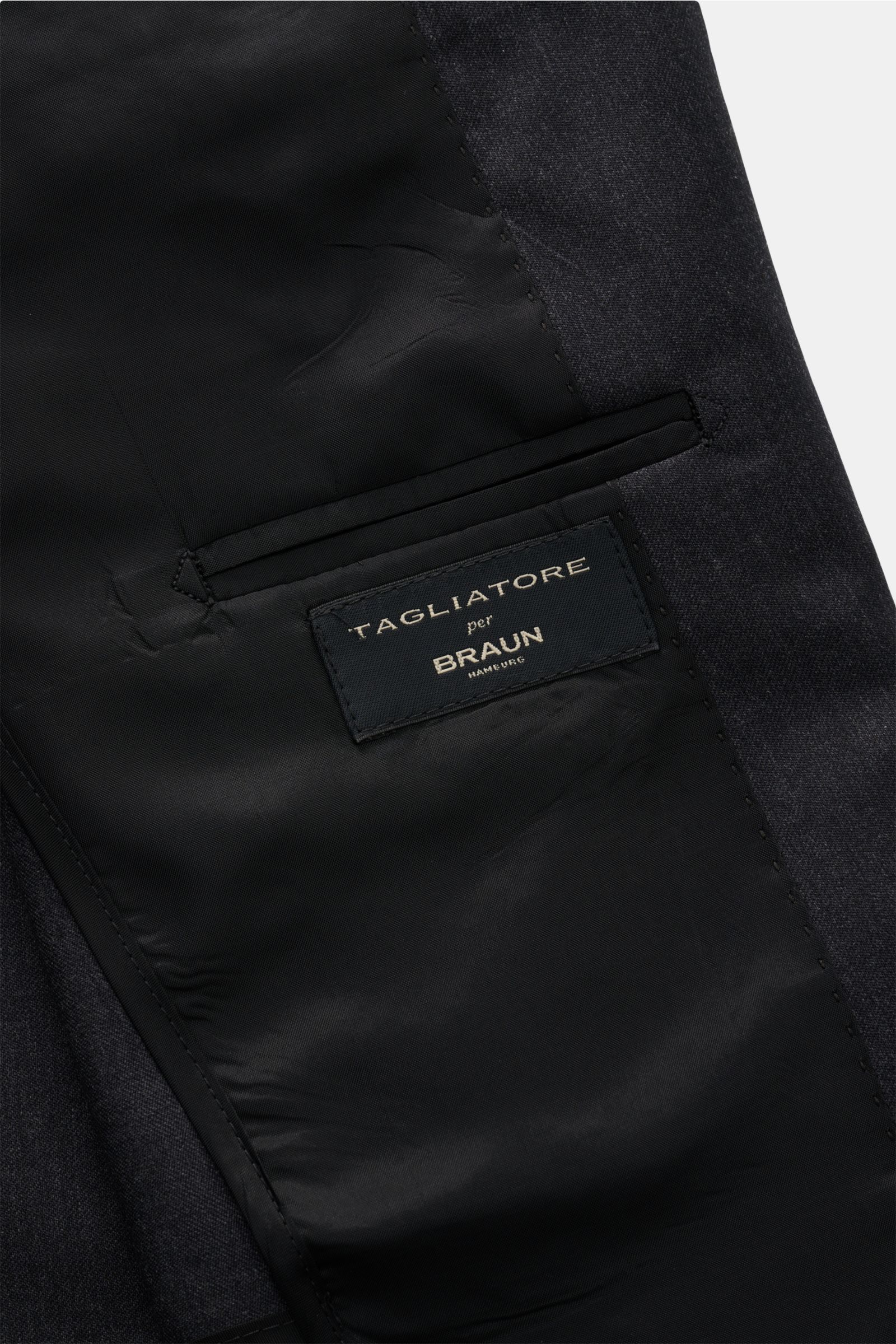 Close-up inside view of the Tagliatore Anzug 'Vesuvio' dunkelgrau meliert jacket showing the black inner lining and brand label, highlighting exquisite craftsmanship and premium materials. Zeitgenössisches Design trifft italienische Tradition aus dem Haus