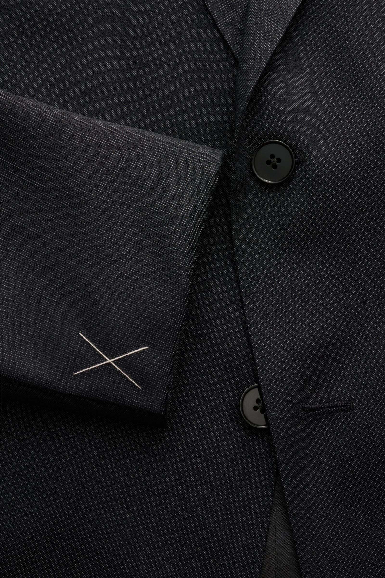 Nahaufnahme des Zegna Anzugs anthrazit aus feinem Twill, Fokus auf Ärmel mit Nahtkreuz und zwei Knöpfen des taillierten Sakkos.