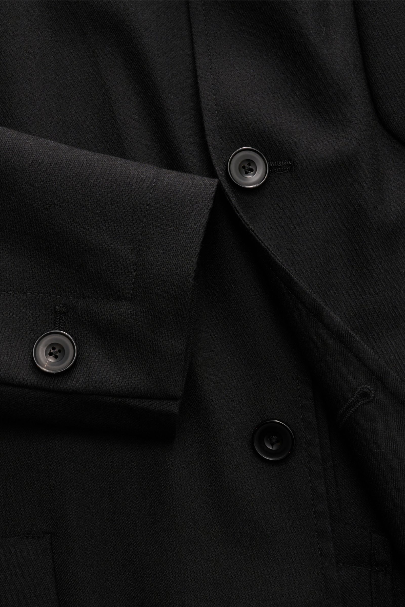 Nahaufnahme des schwarzen Santaniello Anzugs aus Wolle-Microfaser-Mix, Regular Fit mit Overshirt-Sakko und Knöpfen.