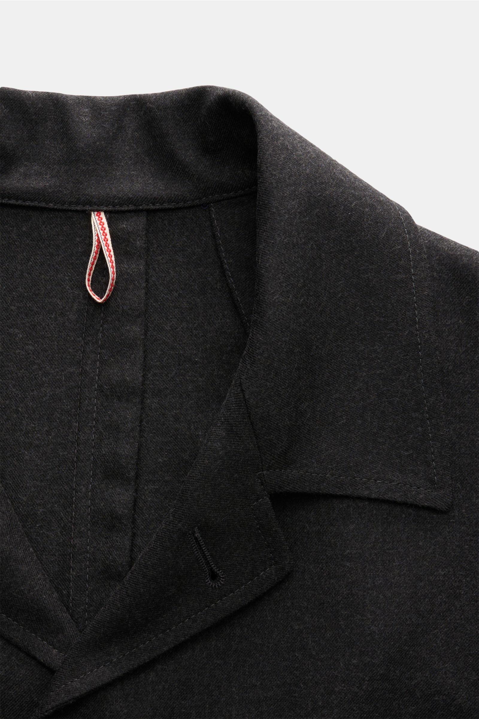 Close-up front view of the collar and lapel of the Santaniello Anzug dunkelgrau meliert, a dark grey melange casual suit made from a wool-microfiber mix with a soft twill texture, Regular Fit, featuring an overshirt-style jacket with a variable collar, no