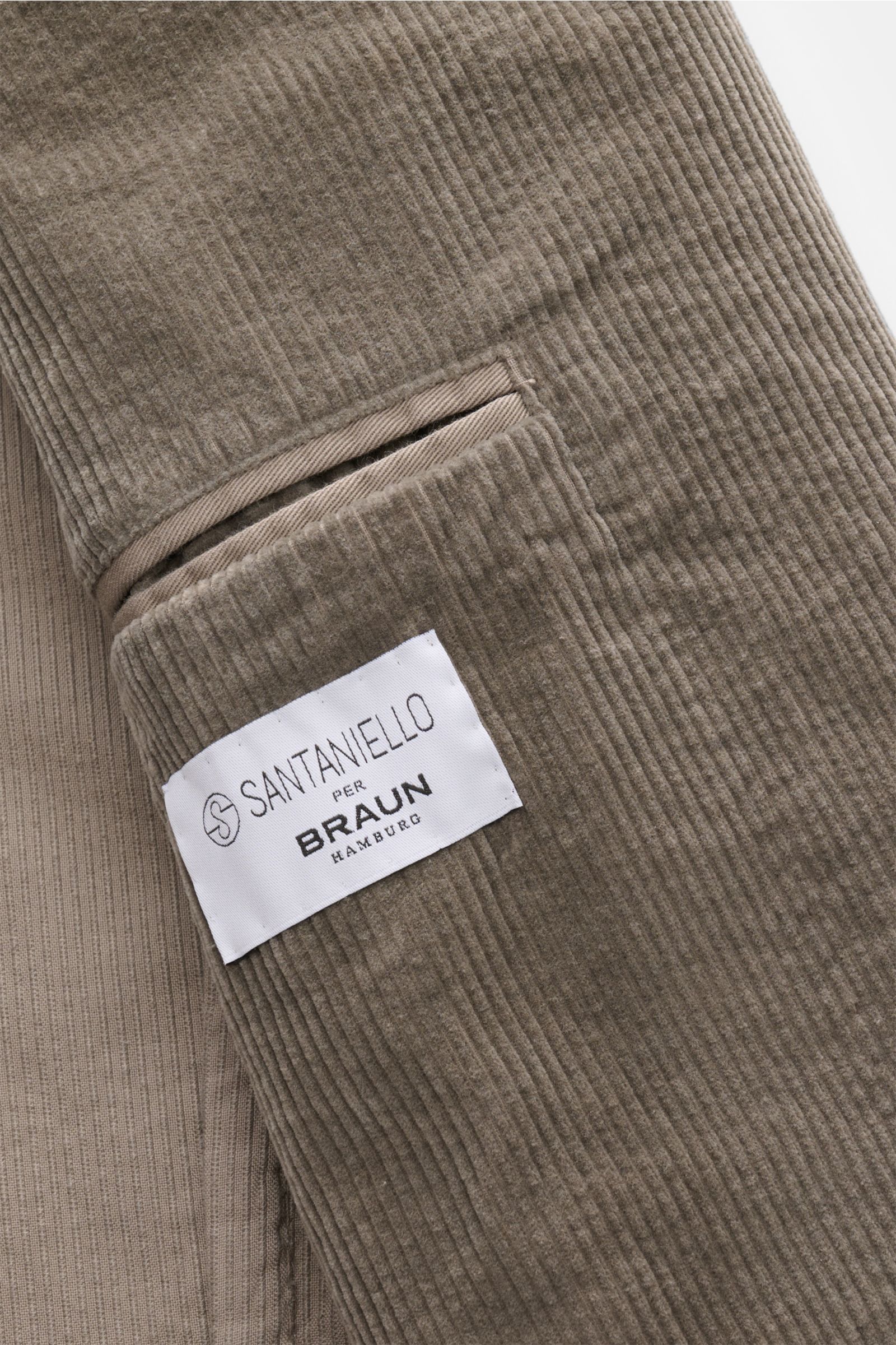 Close-up view of the soft cord fabric and label of the Santaniello Cord Anzug grau, made of cotton and cashmere blend with fine ribbed texture.