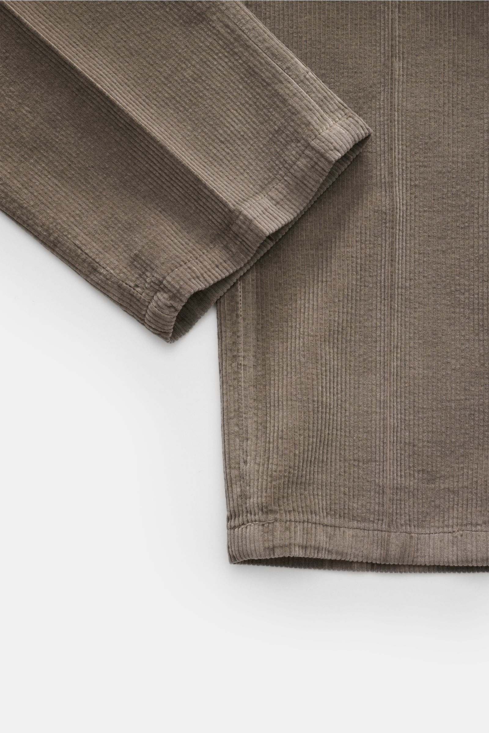 Close-up top view of the sleeve and hem of the Santaniello Cord Anzug grau, a slim fit cotton-cashmere corduroy suit with soft texture, highlighting the fabric's ribbed detail and stitching.