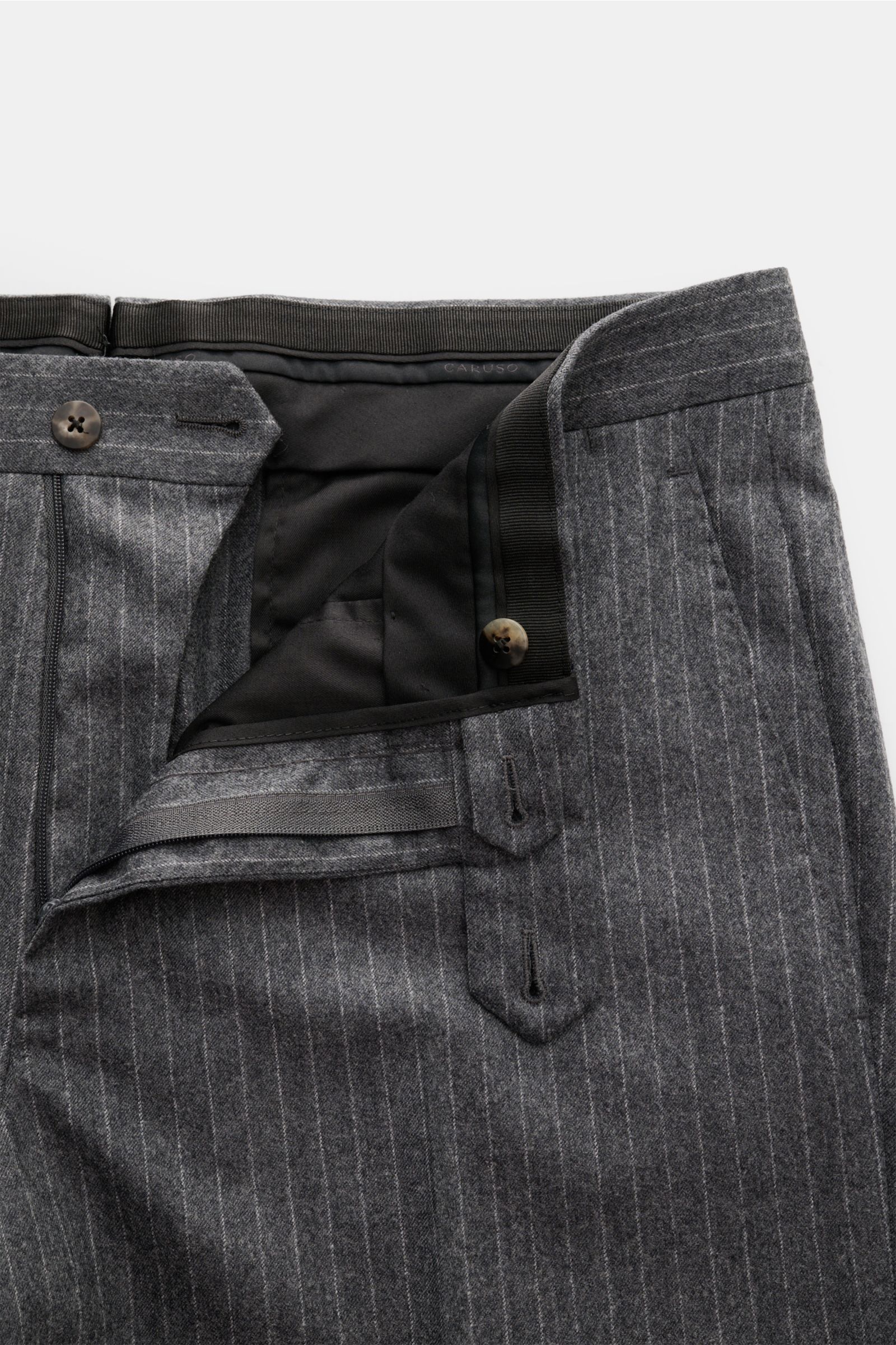 Close-up view of the waistband and zipper area of the Caruso Anzug 'Aida' dunkelgrau gestreift trousers, made of lightweight wool fabric with fine pinstripes and soft touch. The image highlights the regular thigh width, button and zipper closure, and inte