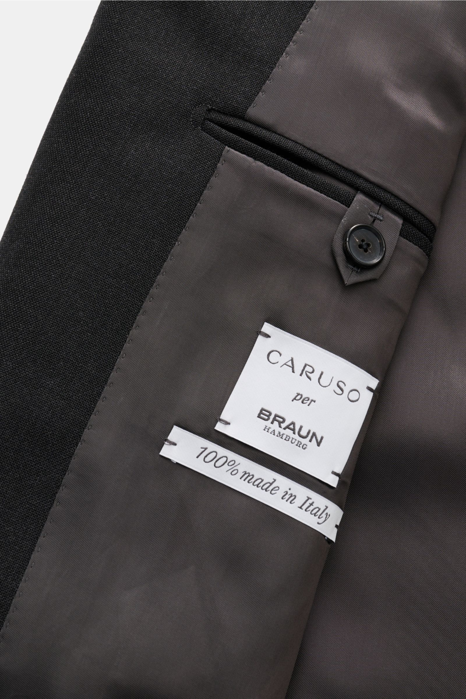 Innenansicht des Caruso Anzug 'Aida' anthrazit mit feinem weichem Futter, Innentaschen und Etiketten, fotografiert aus Nahaufnahme.