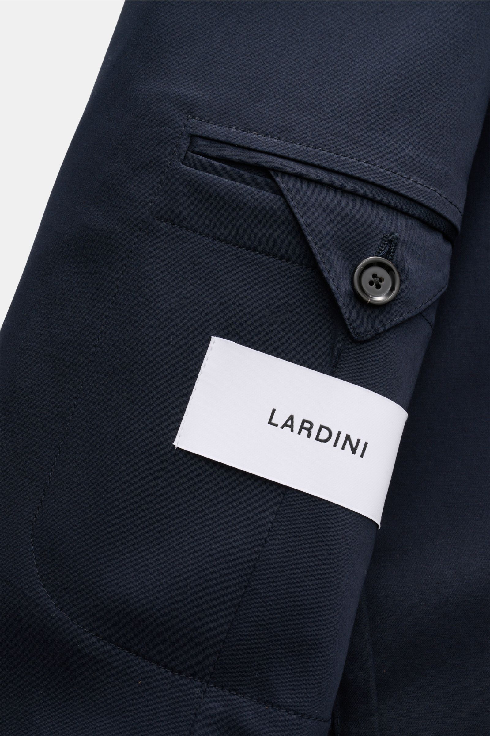 Nahaufnahme des navyfarbenen Lardini Anzugs aus elastischer Baumwolle, Fokus auf Ärmel mit Knopf und Label.