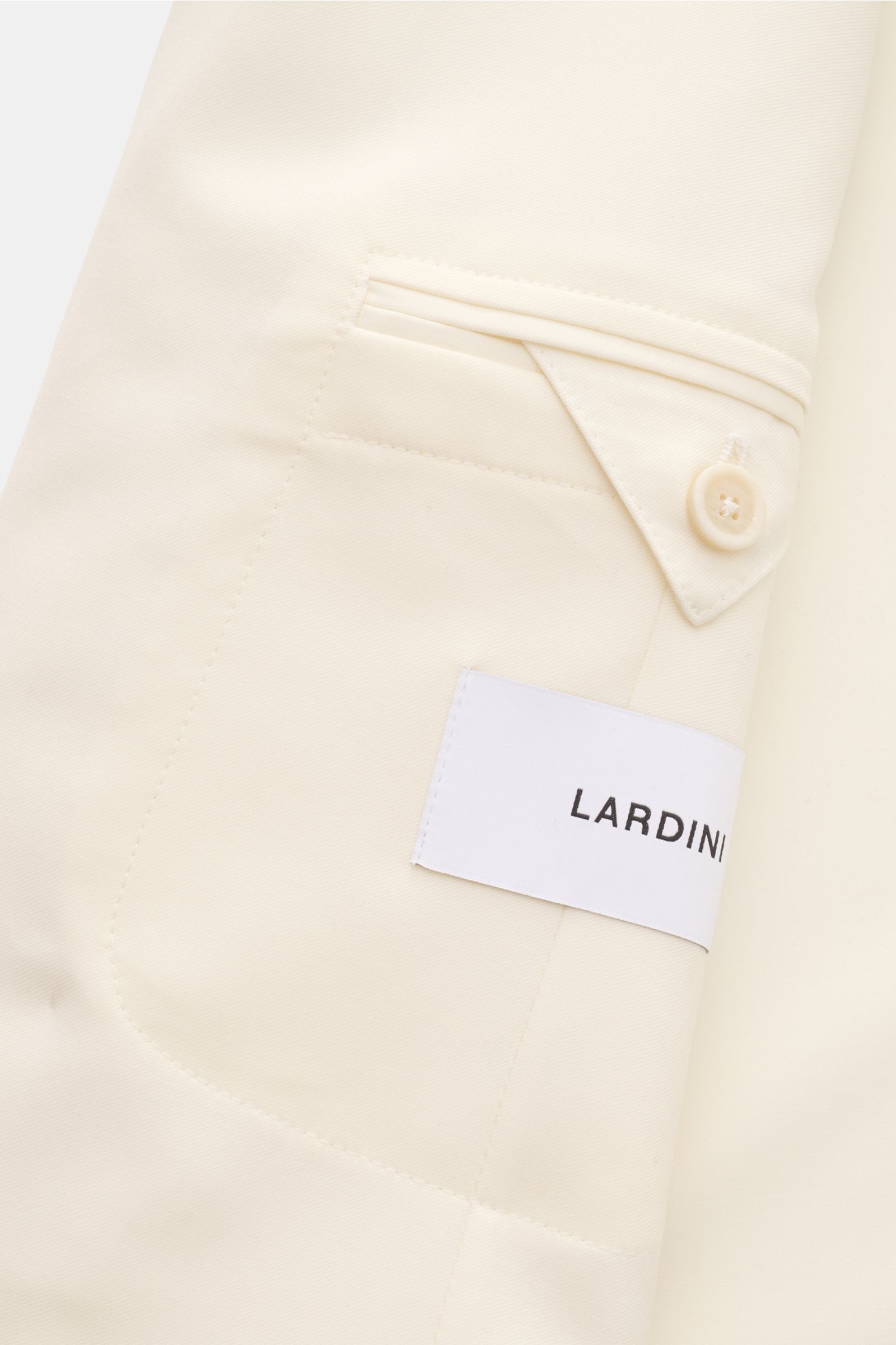 Close-up view of Lardini Anzug creme sleeve detail showing soft pure virgin wool fabric, button cuff, and Lardini label.