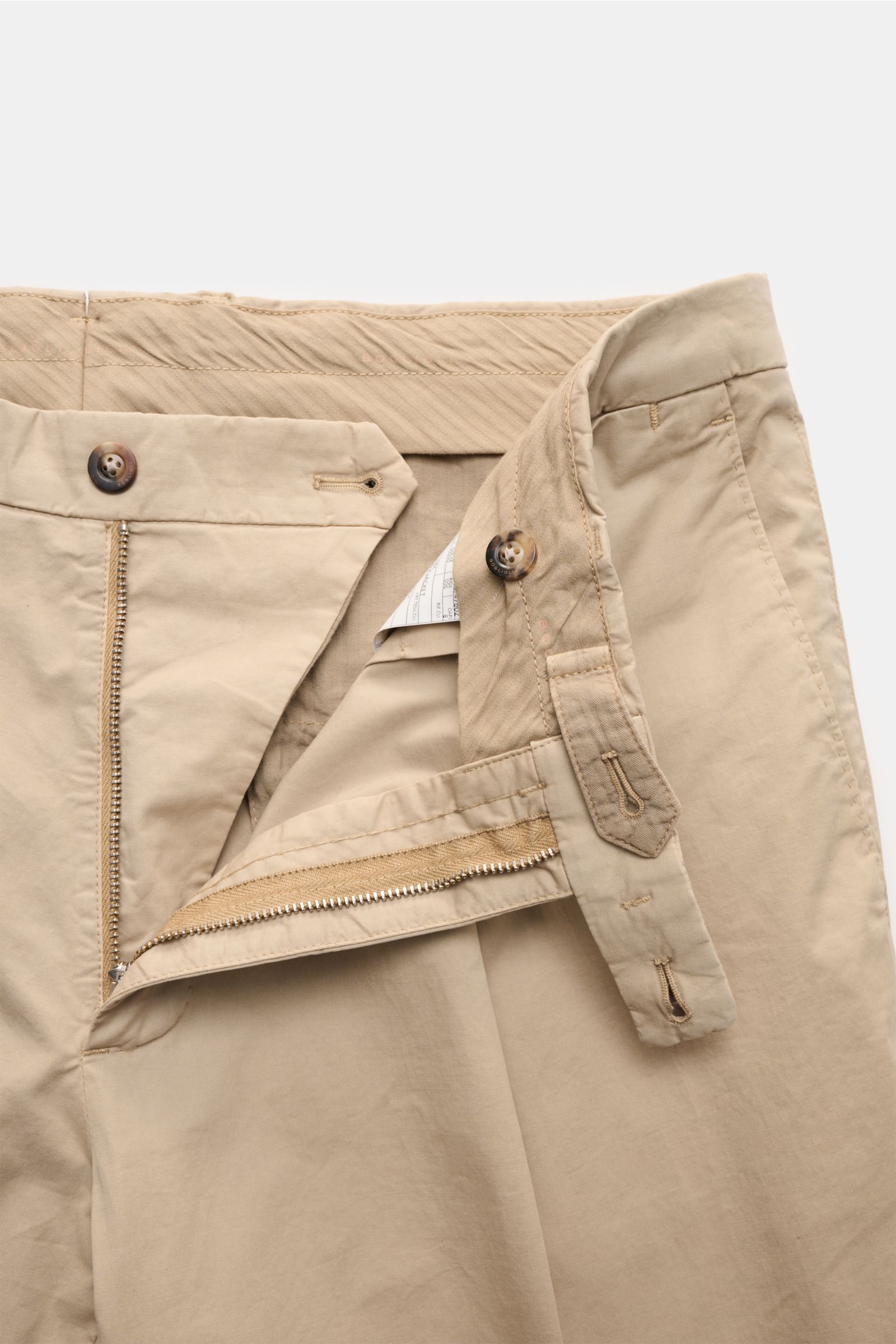 Boglioli Anzug 'K. Jacket' beige Hose offen liegend, Baumwoll-Twill, leicht elastisch, Slim Fit, hoher Bund, Reißverschluss, Bundknöpfe, seitliche Taschen, Detailaufnahme frontal.