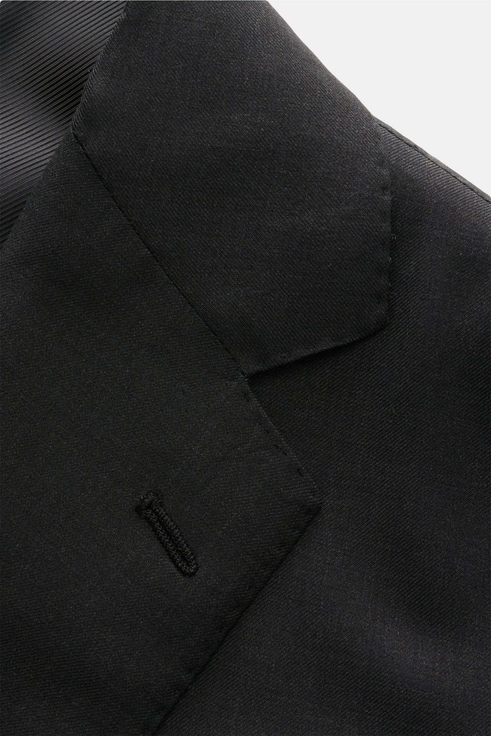 Nahaufnahme des fallenden Revers vom Stile Latino Anzug 'Vincenzo' anthrazit, feiner Twill aus reiner, weicher Wolle, fotografiert von schräg oben.