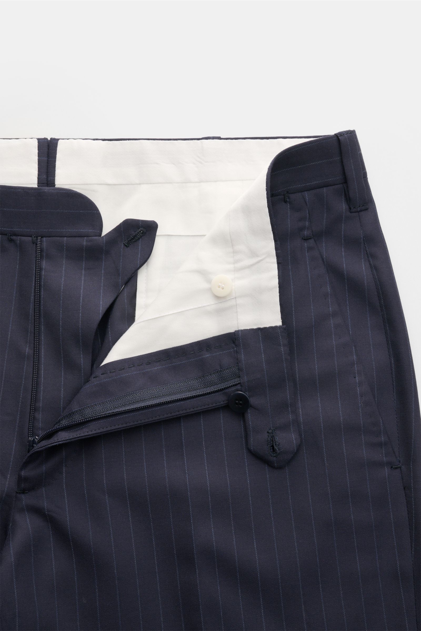 Cesare Attolini Anzug navy gestreift, Detailansicht der geöffneten Bundpartie der Hose aus Super 160’S Wolle mit feinen Nadelstreifen.
