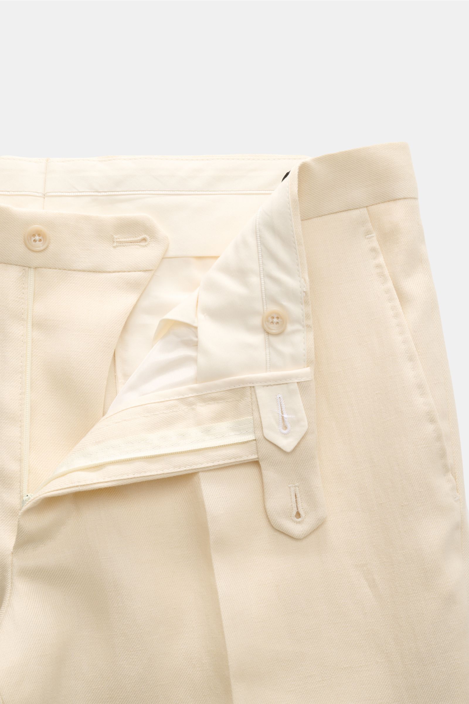 Tagliatore Leinenanzug 'Vesuvio' creme, Detailansicht der halb gefütterten Hose aus weichem, reinem Leinen mit Knöpfen und Reißverschluss.