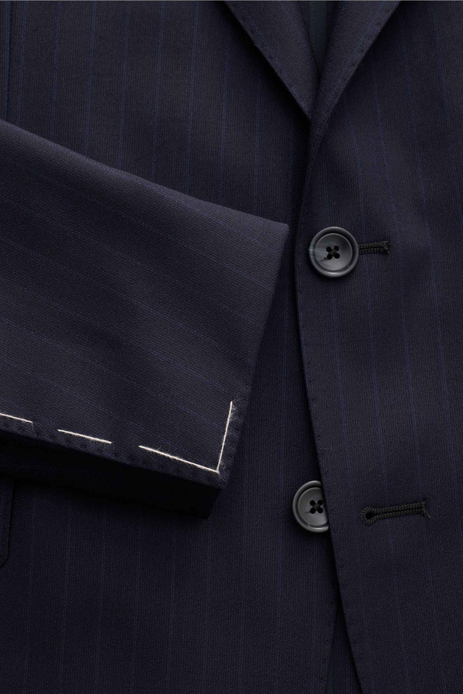 Close-up front view of the Tagliatore Anzug 'Vesuvio' navy gestreift suit jacket, showcasing slim fit elastic wool fabric with soft touch and classic pin-stripes, featuring a tailored two-button style, falling lapel with pin, and detailed stitching on the