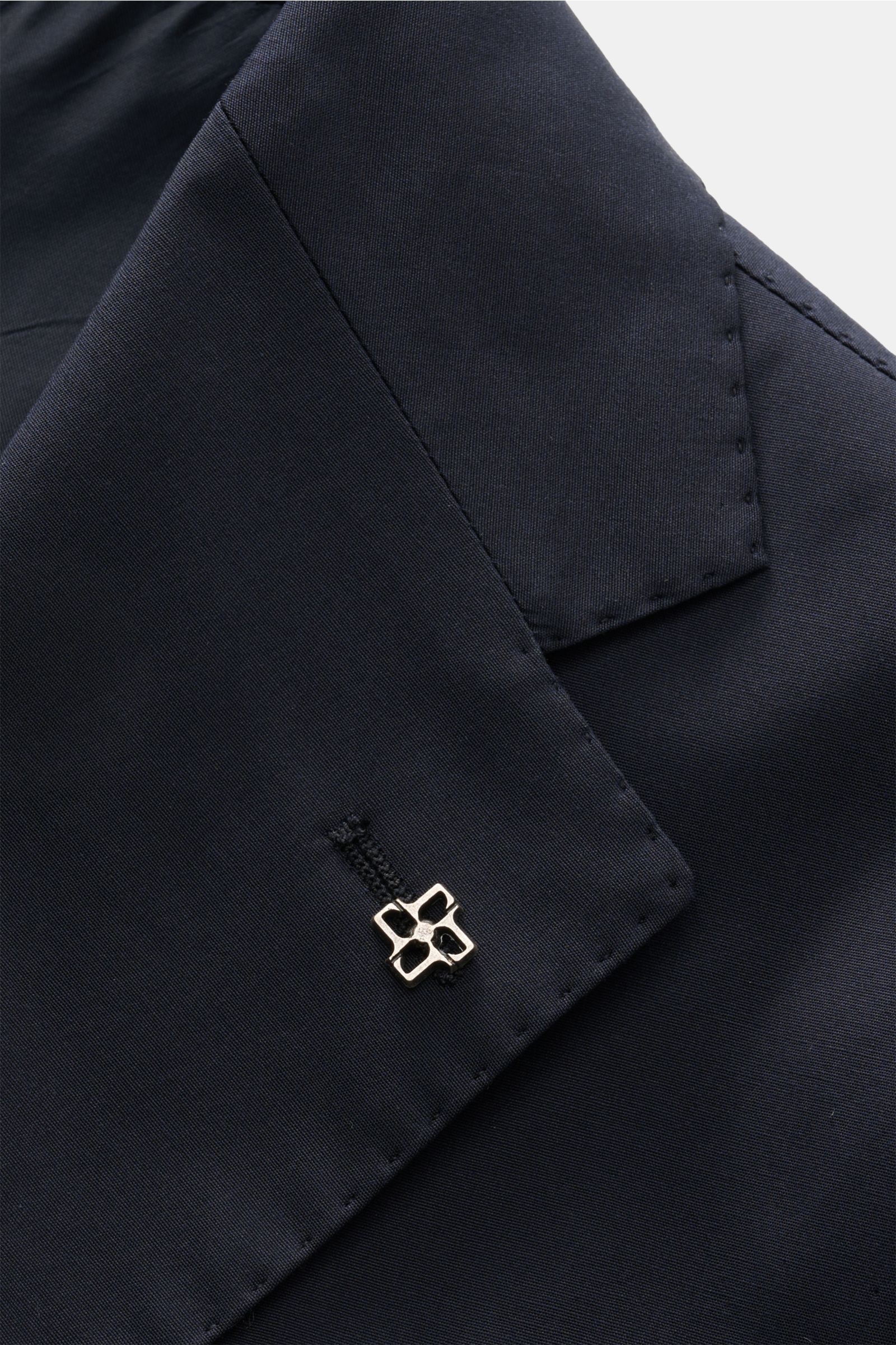 Detailaufnahme des fallenden Revers mit Pin am Sakko des Tagliatore Anzugs 'Vesuvio' navy aus elastischer Baumwolle, Slim Fit.