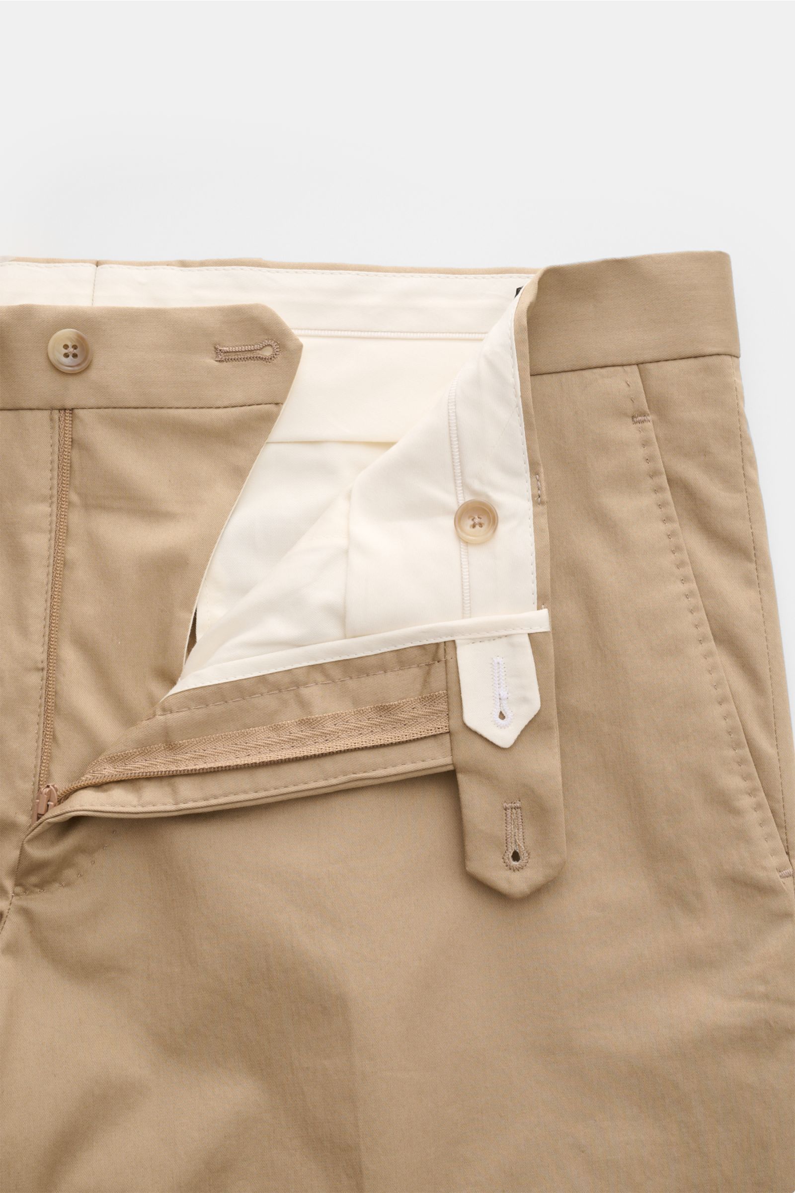 Beige Hose des Tagliatore Anzugs 'Vesuvio' aus elastischer Schurwolle mit schmal zulaufendem Schnitt, Reißverschluss und Bundknöpfen, frontal fotografiert.