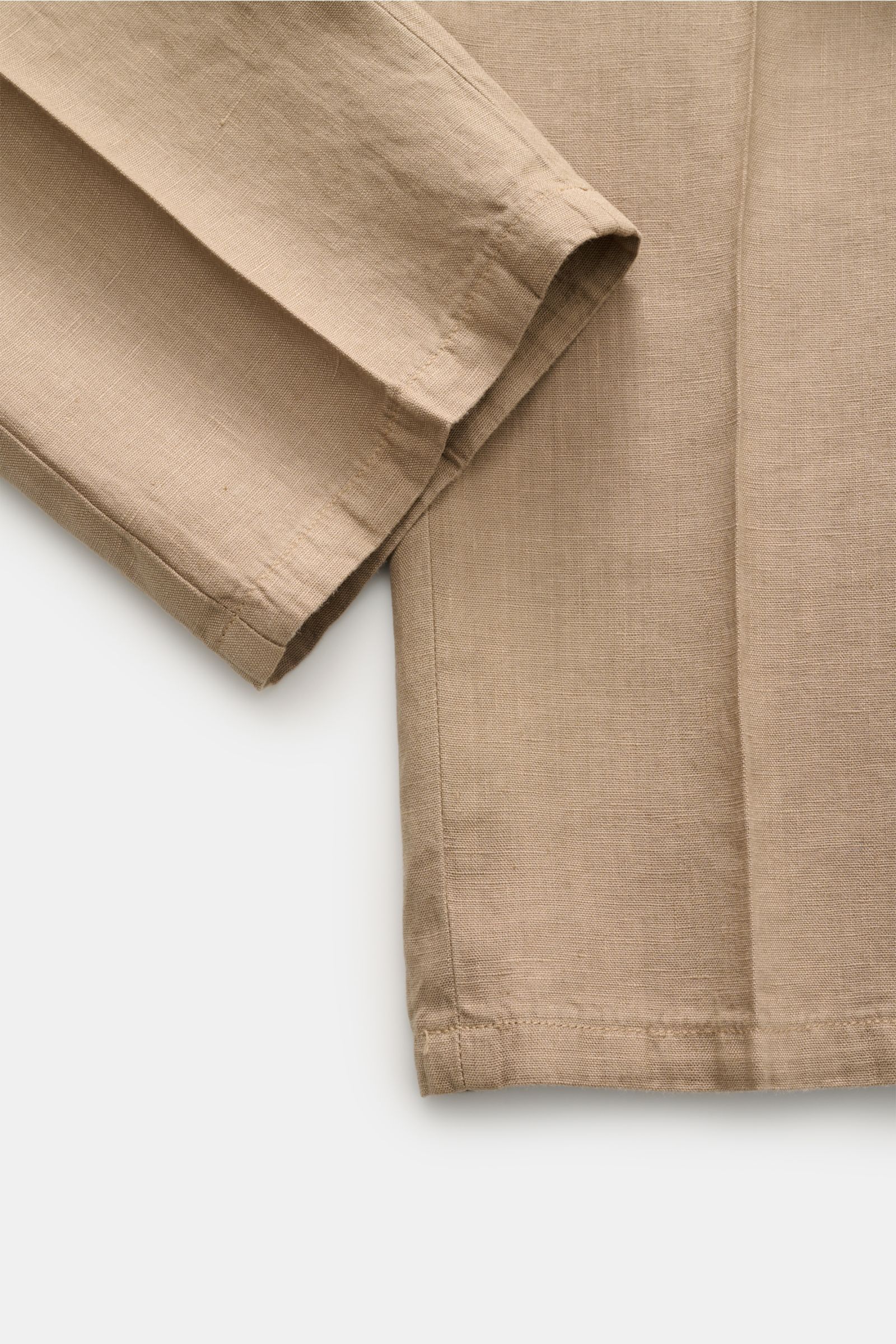 Nahaufnahme des Ärmels und Teils der Vorderseite des Santaniello Anzug taupe aus reinem Leinen, vintage Optik, weicher Griff, Slim Fit, unstrukturierter Zwei-Knopf-Sakko mit fallendem Revers, aufgenommen aus schräger Draufsicht.