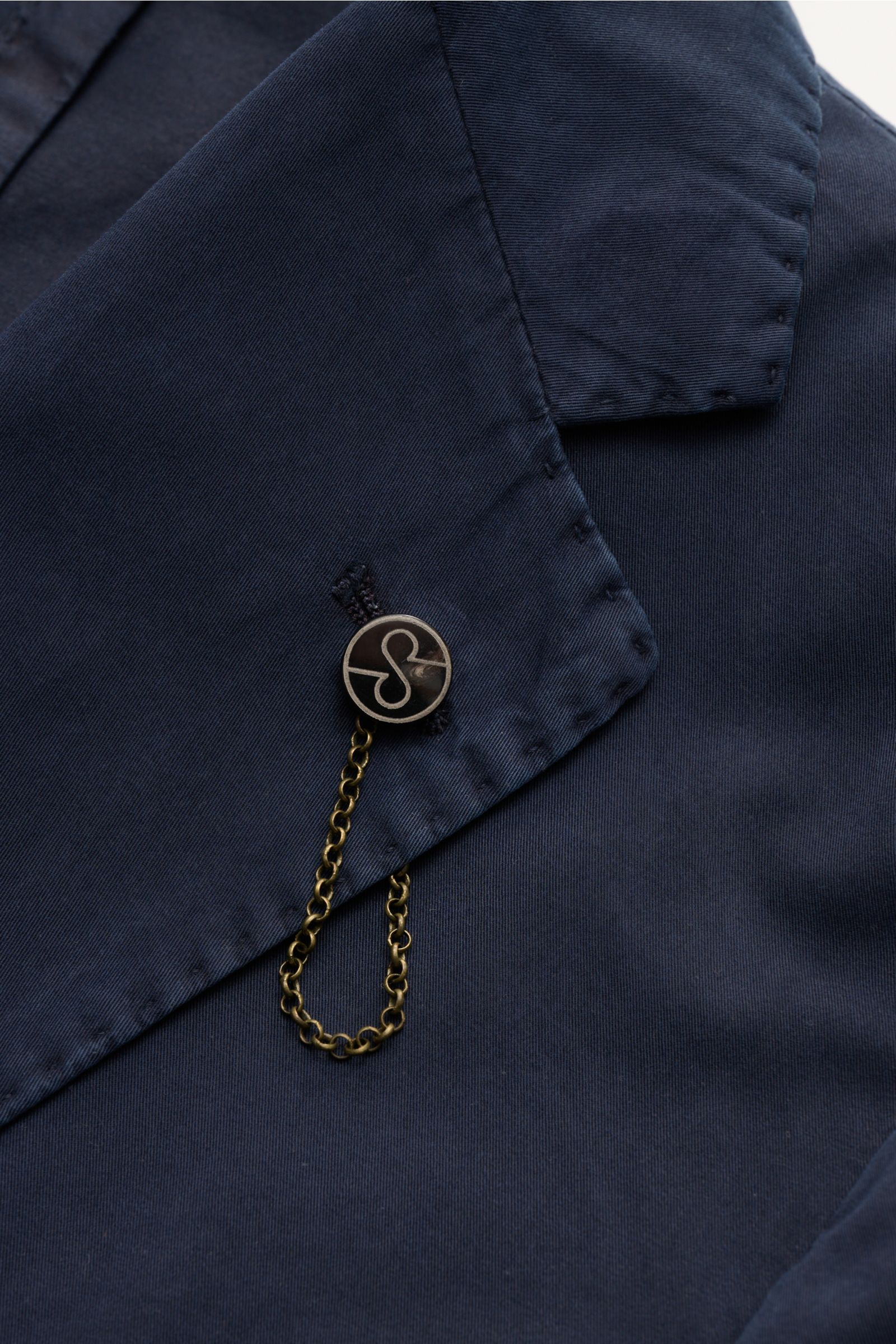 Nahaufnahme des fallenden Revers vom Santaniello Anzug navy aus weichem Baumwoll-Twill mit Ketten- und Knopfdetail.