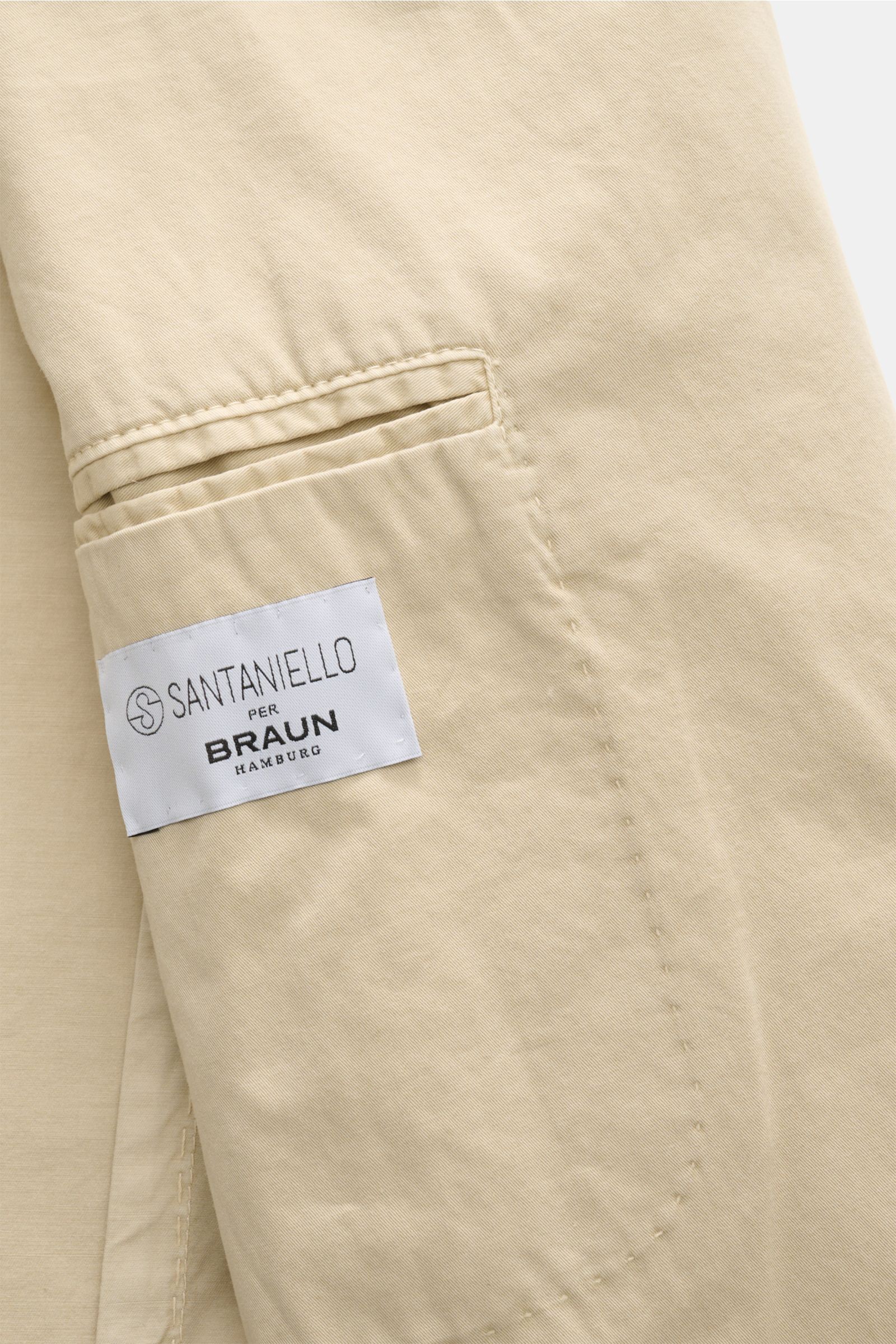 Close-up side view of Santaniello Anzug sand jacket sleeve in soft cotton twill with label, showcasing casual elegance and fine detailing.