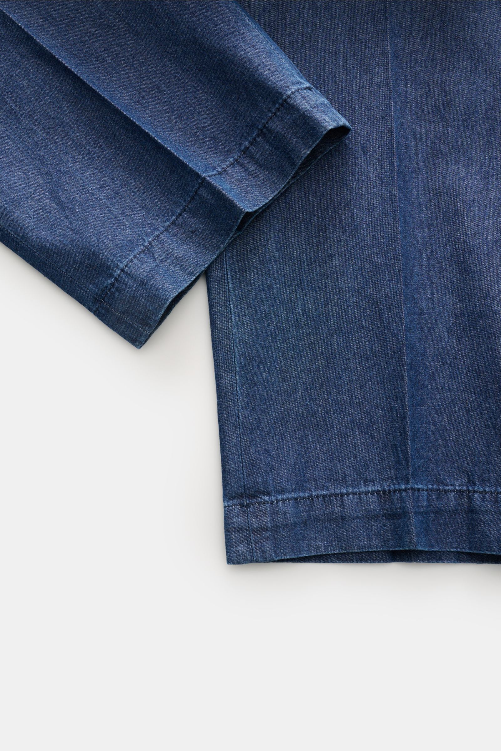 Close-up front view of Briglia 1949 Suit 'Greco' dark blue jacket sleeve and hem, showcasing denim look, pure cotton, soft feel, slim fit, unconstructed design. Modern tailoring for summer: This suit combines a denim look with lightweight cotton fabric – 