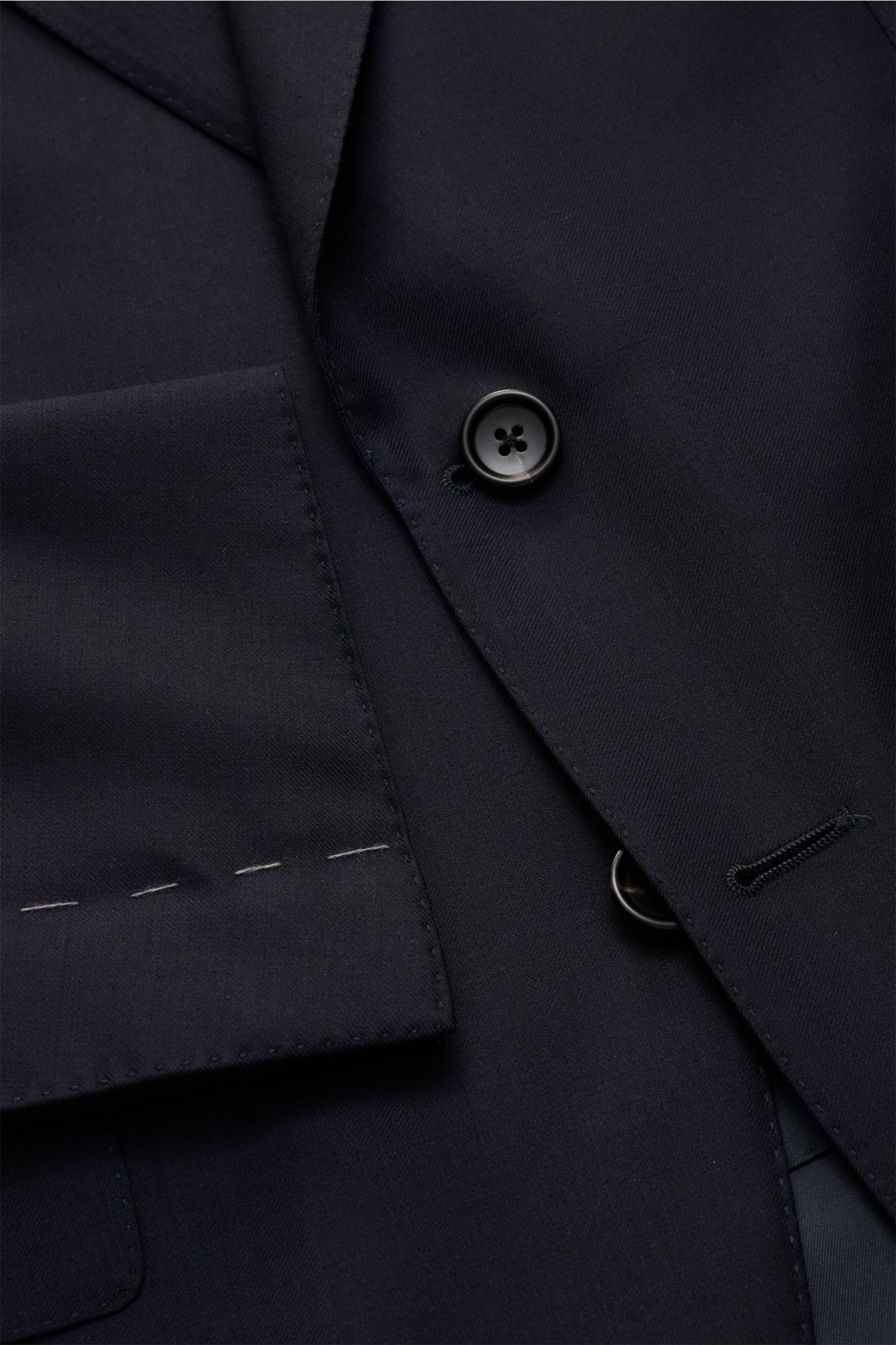 Nahaufnahme des luxuriösen Tom Ford Anzug 'Shelton' navy, fein gewebte Wolle, schmaler Slim Fit mit Patten-Taschen und Knöpfen.