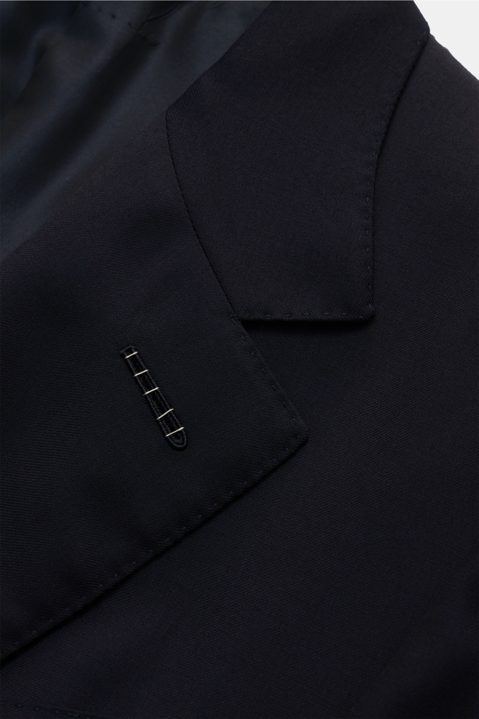 Nahaufnahme des Revers und Knopfloch des Tom Ford Anzug 'Shelton' navy aus reiner Wolle mit feiner Webstruktur, fotografiert aus seitlicher Perspektive.
