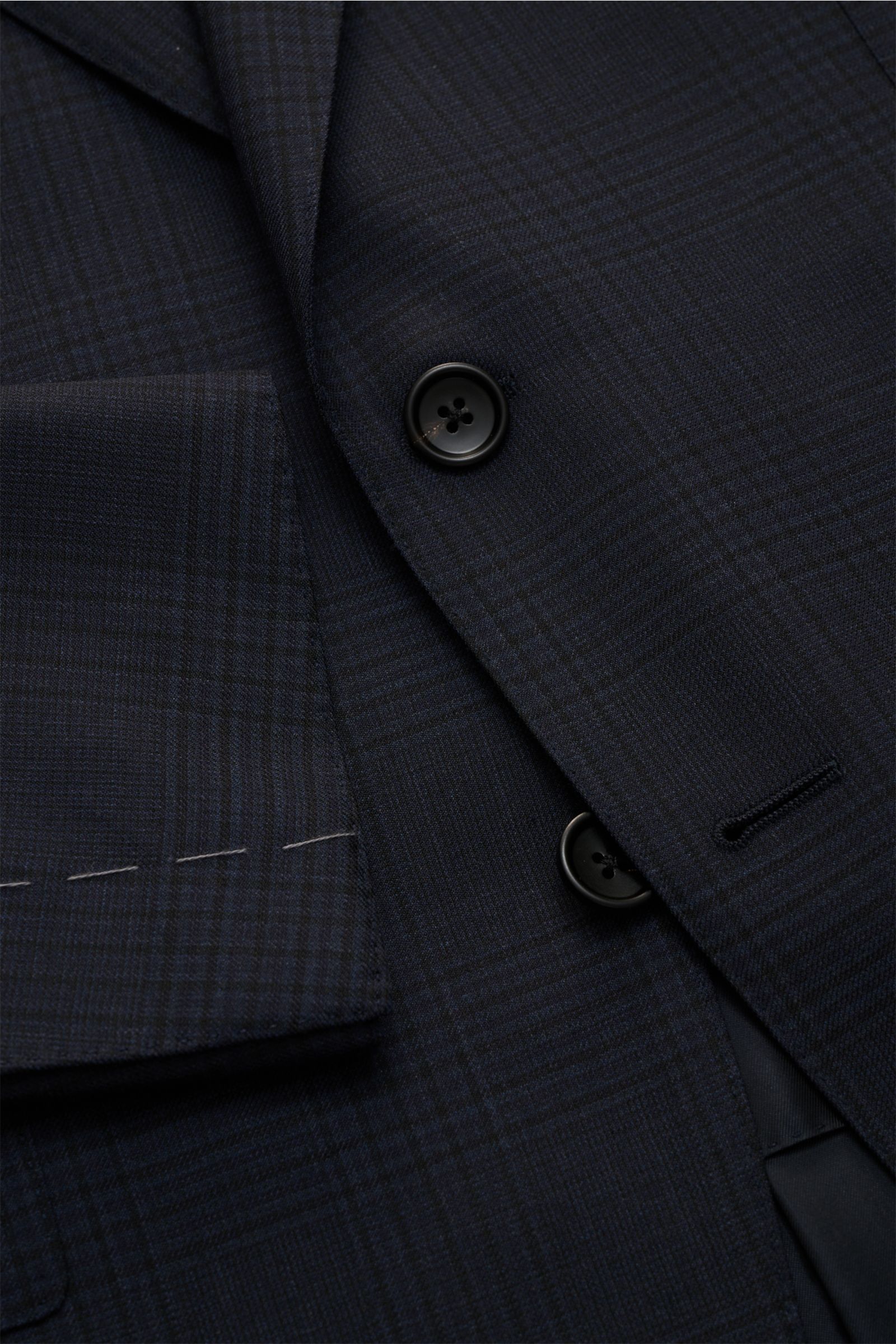 Nahaufnahme des navy/schwarz karierten Tom Ford Anzugs 'Shelton' mit Slim Fit, Patten-Taschen und feiner Wollstruktur aus schräger Perspektive.