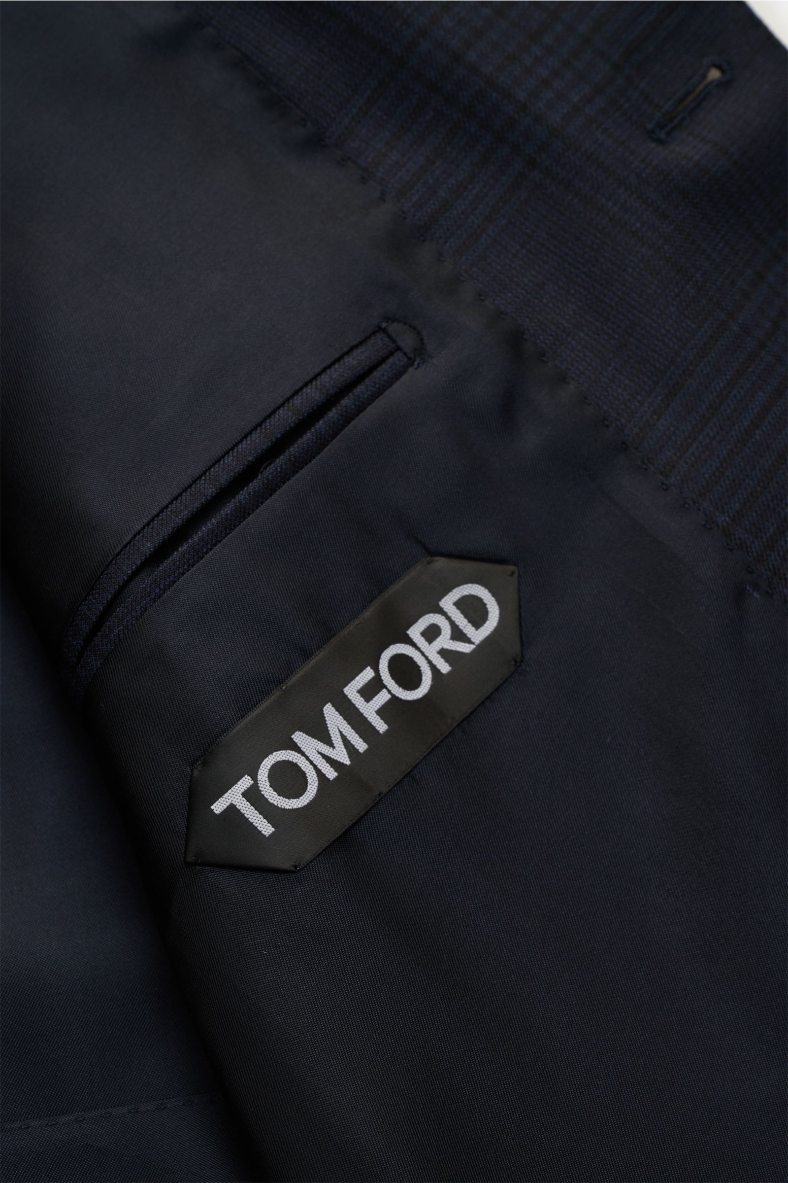Nahaufnahme von innen mit Tom Ford Label, Seitennahttasche und fein gewebtem Stoff des Tom Ford Anzugs 'Shelton' navy/schwarz kariert.