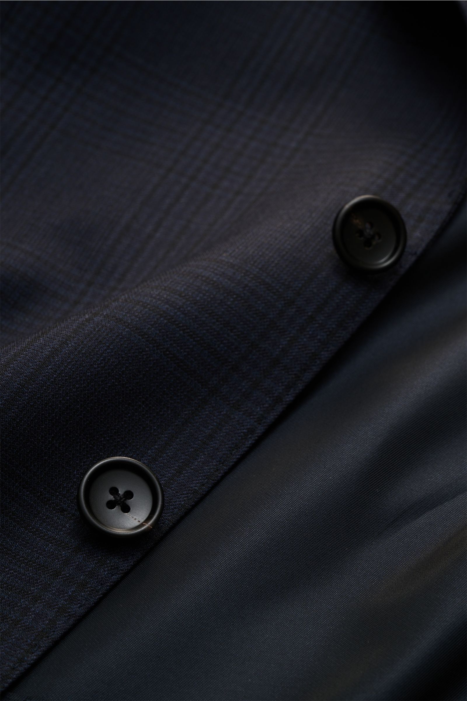 Tom Ford Anzug 'Shelton' navy/schwarz kariert Detailaufnahme von feiner Wolle mit Glencheck, Knöpfen und glattem Futterstoff, nah und schräg fotografiert.