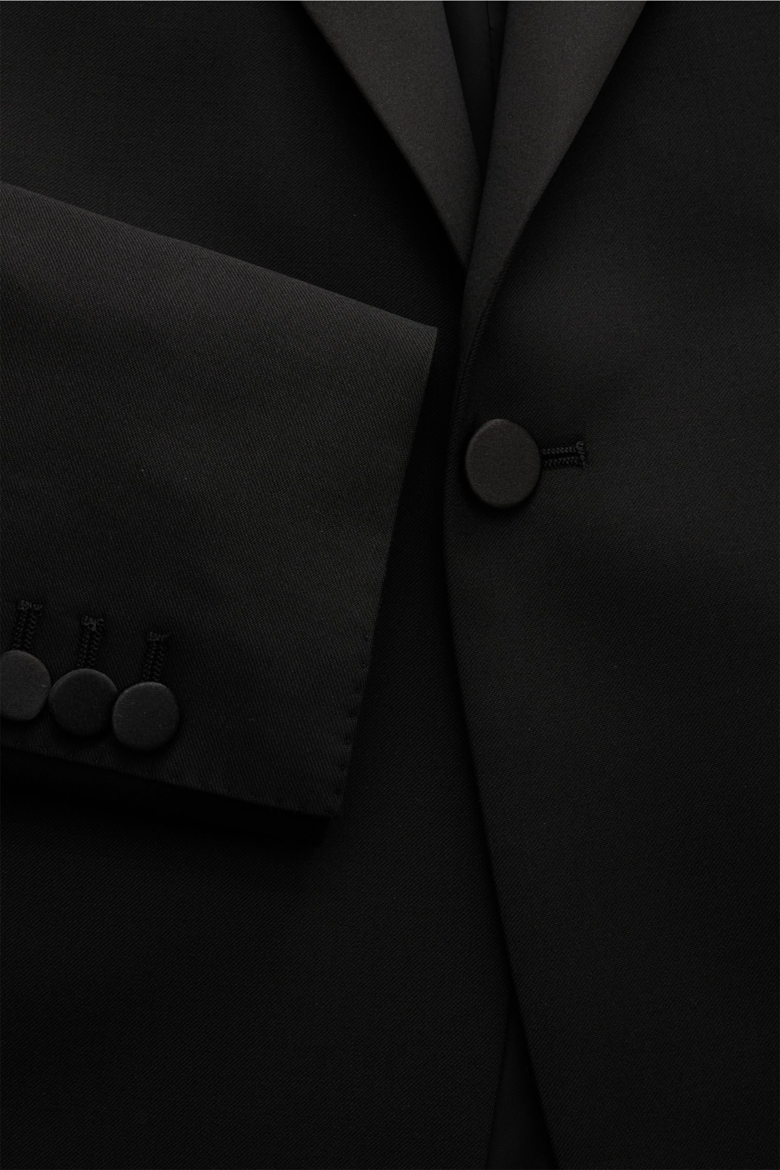 Tagliatore Smoking 'Napoli' schwarz, Slim Fit aus reiner Super 110'S Schurwolle, tailliertes Ein-Knopf-Sakko mit Satinrevers, Detailaufnahme frontal.
