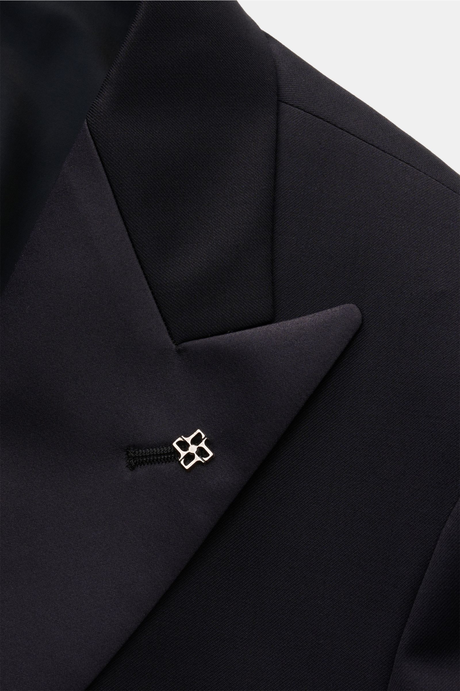 Nahaufnahme des Spitzrevers mit Satinspiegel und labeltypischem Pin am Tagliatore Smoking 'Napoli' dark navy aus reiner Super 110'S Schurwolle.