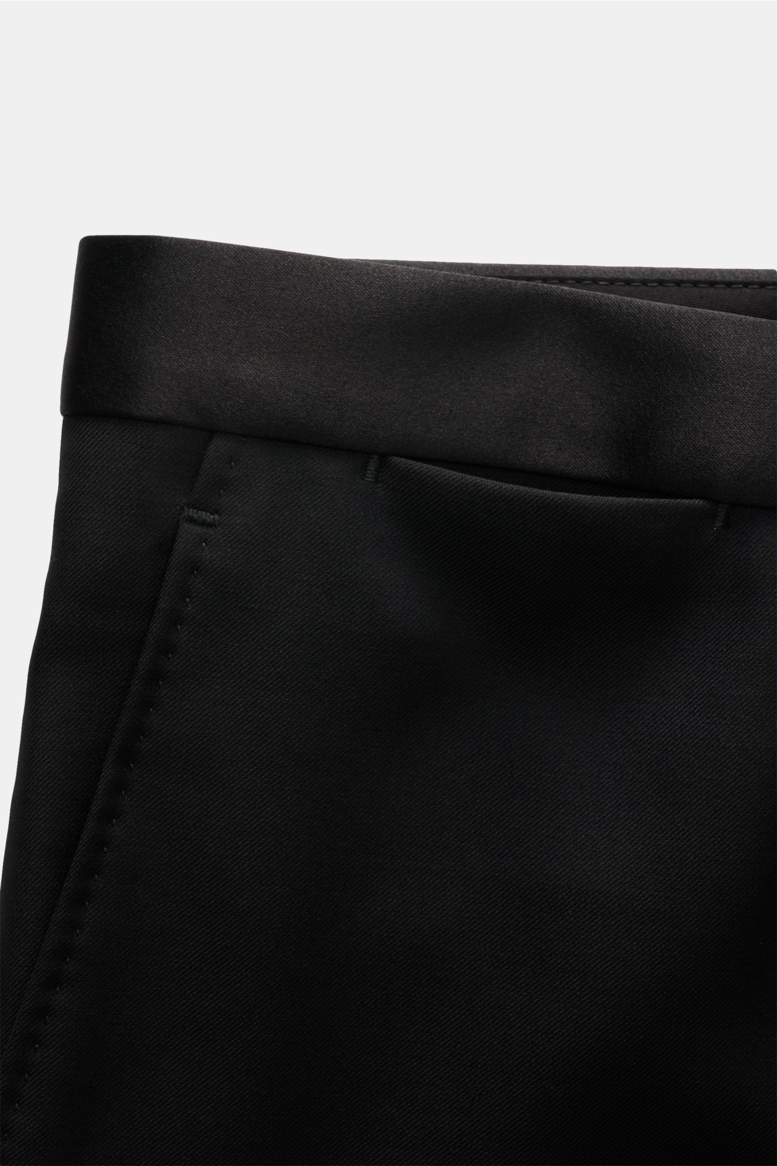 Black satin waistband detail of Tagliatore Tuxedo black trousers, photographed close-up from a side perspective.