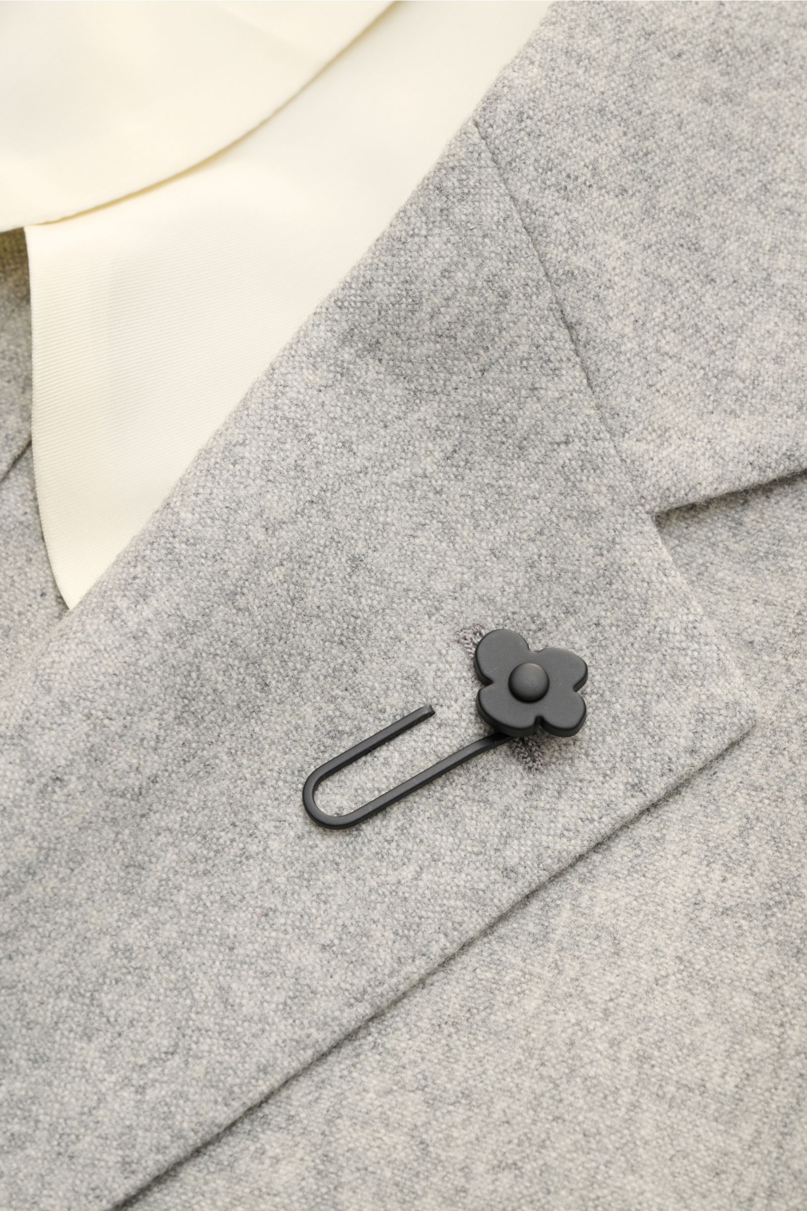 Lardini Sakko hellgrau meliert shown in close-up from a front angle, highlighting the soft wool-cashmere fabric and black flower lapel pin. Für den besonderen Anlass oder das Office – für was Sie sich auch entscheiden, das Unconstucted-Sakko von LARDIN