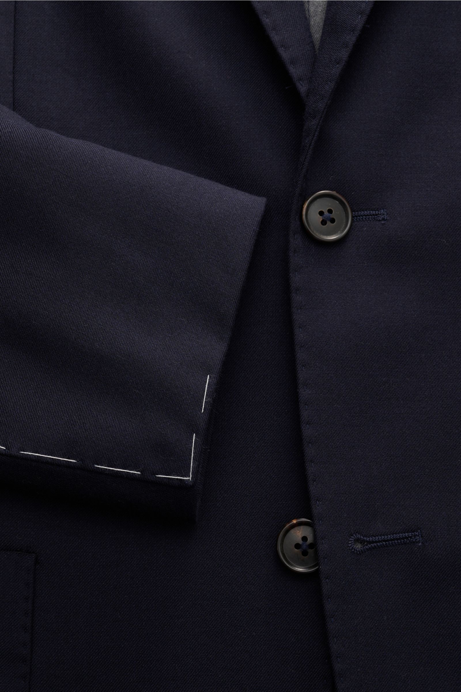 Corneliani Sakko navy aus Schurwolle und Seide, Slim Fit, taillierter Zwei-Knopf-Stil, fallendes Revers, weicher Griff, Detailfoto Ärmelabschluss unfertig.
