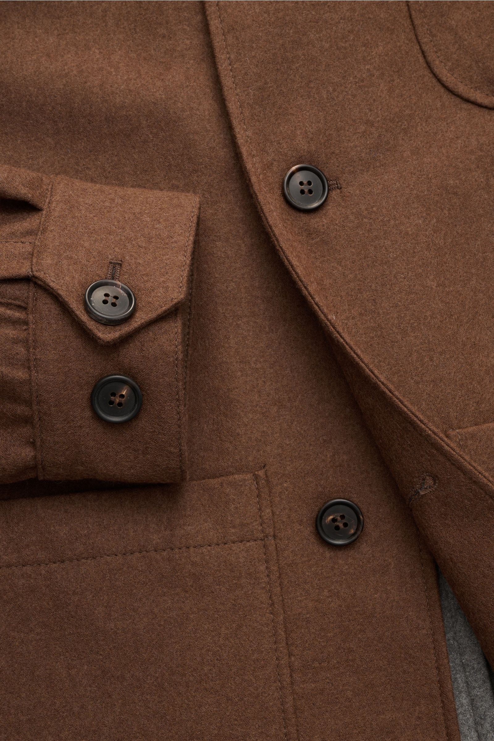 Nahaufnahme des Corneliani Overshirts braun aus Schurwolle und Seide mit Vier-Knopf-Leiste, Manschetten und aufgesetzten Taschen.