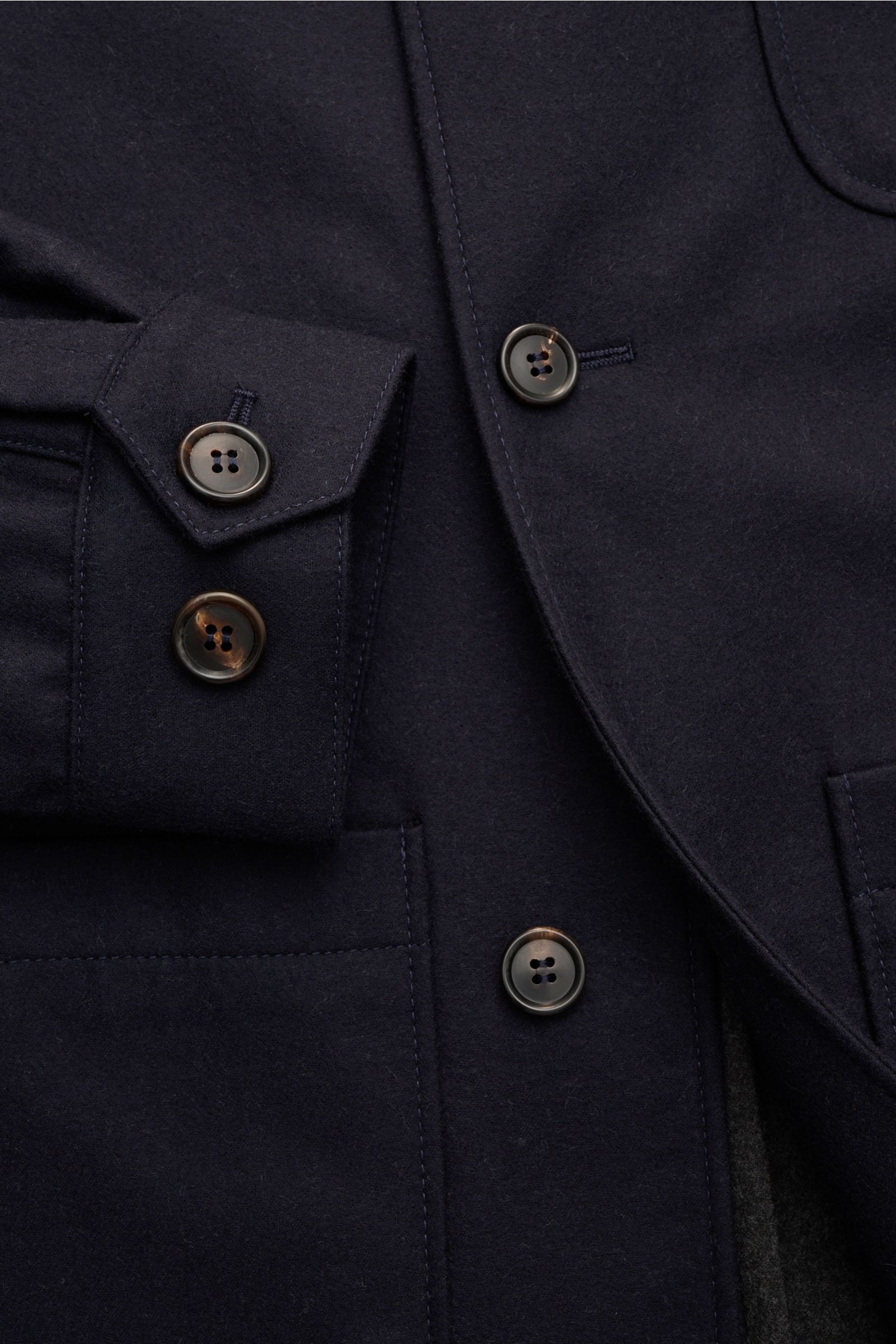 Close-up front view of Corneliani Overshirt navy showing buttons, cuff, and patch pockets on double-face virgin wool and silk fabric.

This overshirt in virgin wool and silk by CORNELIANI is an elegant shirt-jacket hybrid and enhances a variety of styl