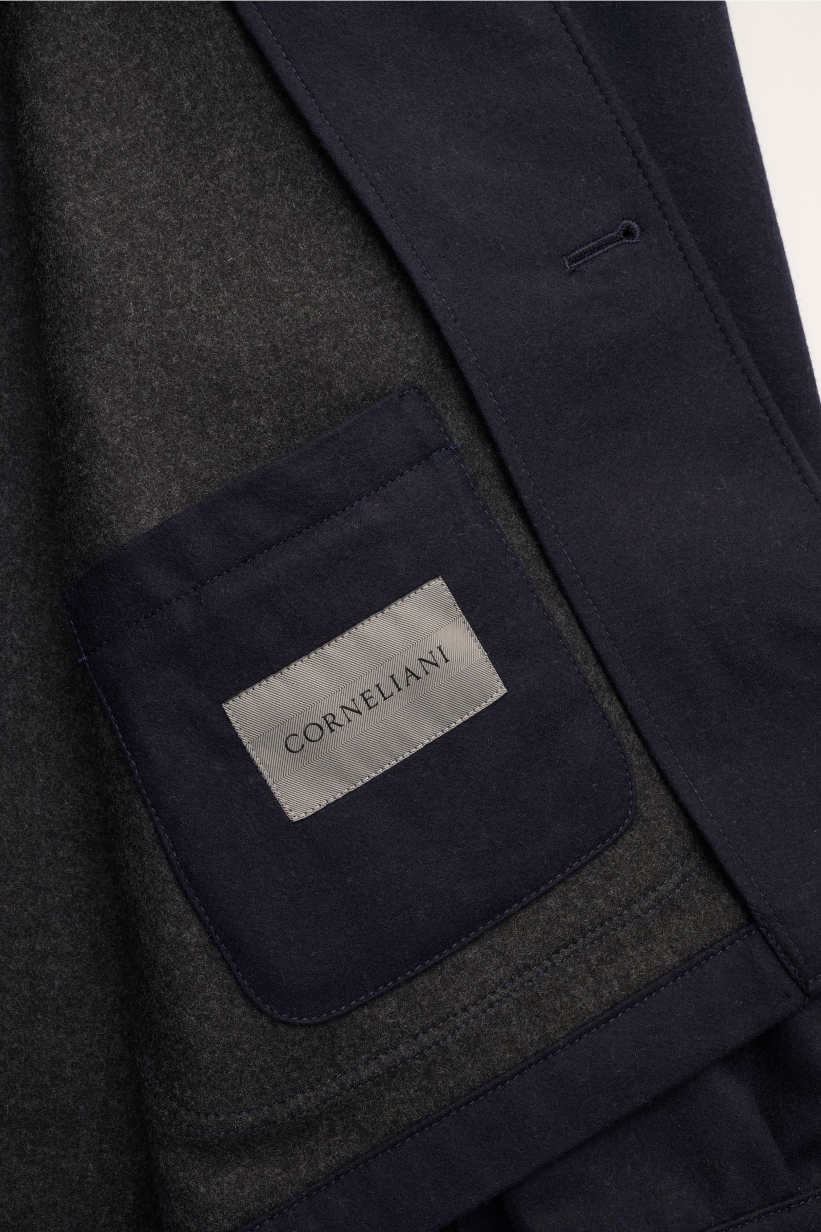Alt tag (125 characters max):
Close-up inside view of Corneliani Overshirt navy showing navy patch pocket with Corneliani label on double-face wool fabric.

Additional description:
This overshirt in virgin wool and silk by CORNELIANI is an elegant shir