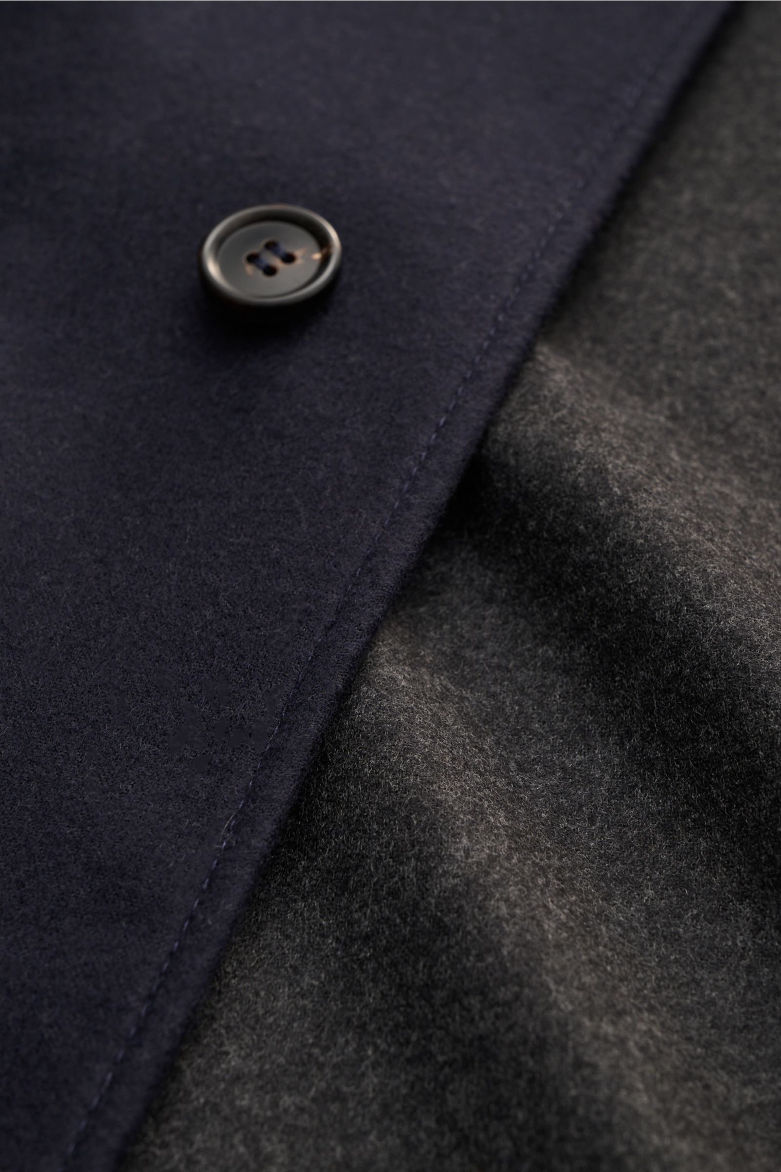 Close-up front view of Corneliani Overshirt navy showing navy double-face fabric with button and grey color-contrasting interior.

This overshirt in virgin wool and silk by CORNELIANI is an elegant shirt-jacket hybrid and enhances a variety of stylish 