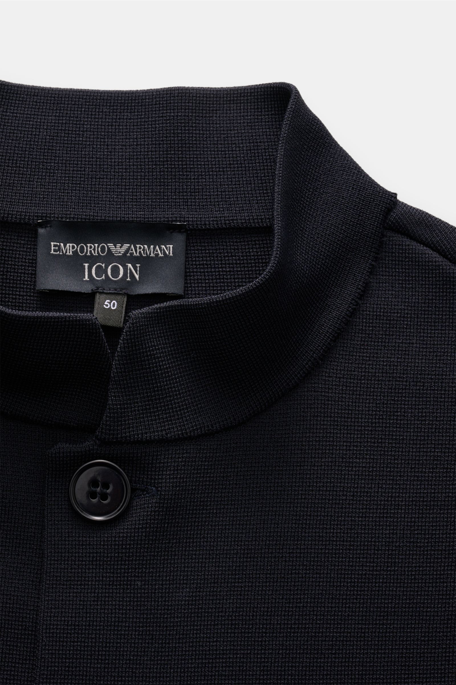 Close-up front view of the collar and button of the Emporio Armani Strickblazer navy, showcasing fine knit texture and slim fit design.

Monochromes Piece von GIORGIO ARMANI: Dieser exklusive Strickblazer aus edlem Materialmix mit Viskose und Microfase