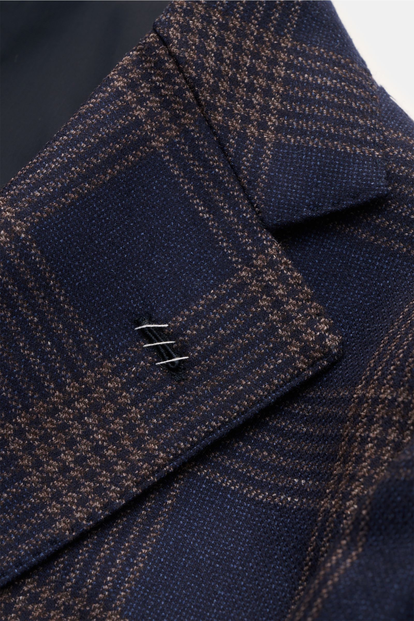 Close-up front-left side detail of Borrelli Smart-casual jacket 'Procida' dark blue/beige checked with classic checked pattern, step lapel, and blend of wool, silk, and linen; slim fit, fitted three-button style, classic breast pocket, patch hip pockets, 