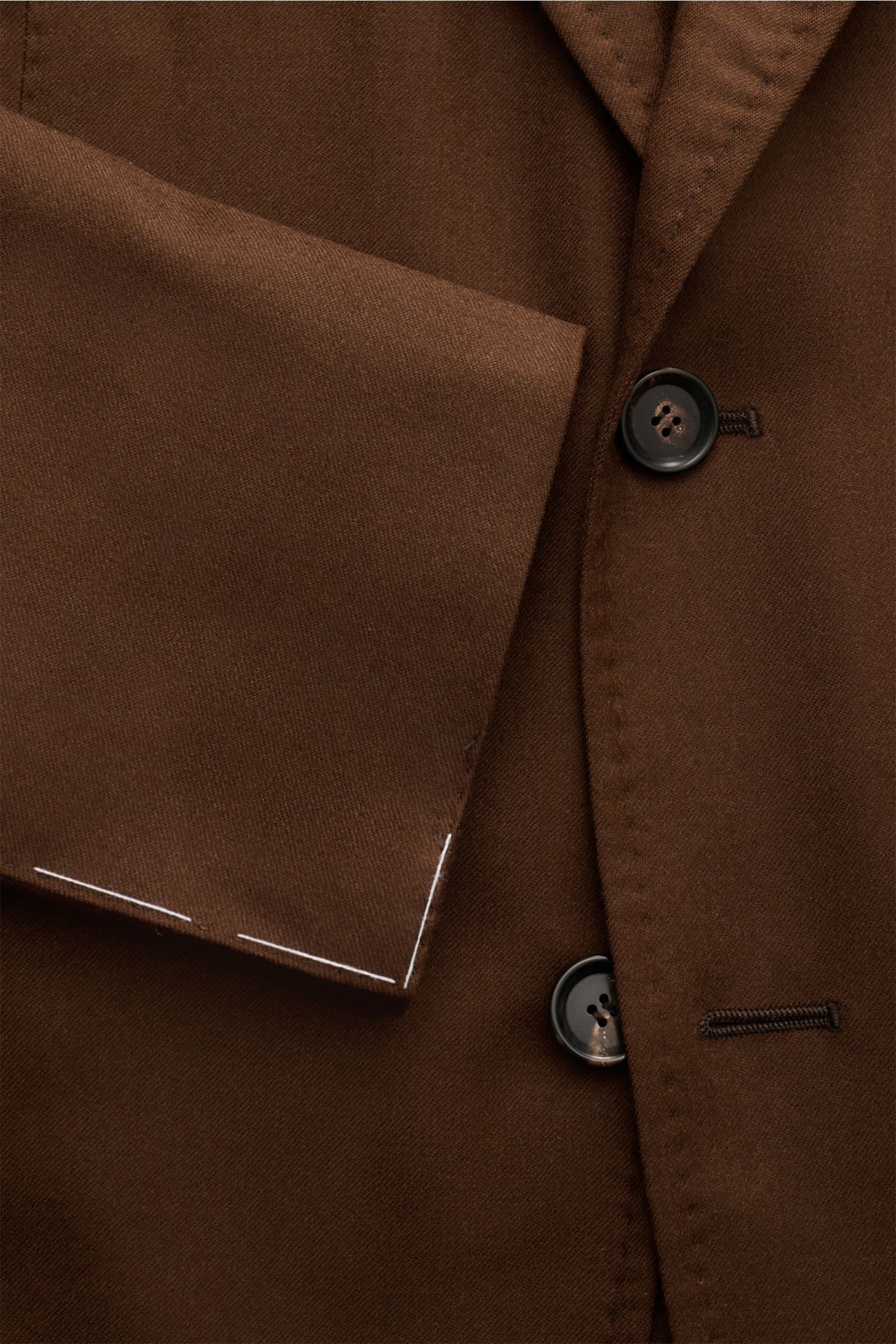 Close-up front view of the Sipario Sakko 'Ginza' braun, a slim fit brown wool blazer with a three-button style, unfinished sleeve ends, and classic pockets, showcasing its super-light, half-lined unconstructed design for style and comfort. Der Inbegrif