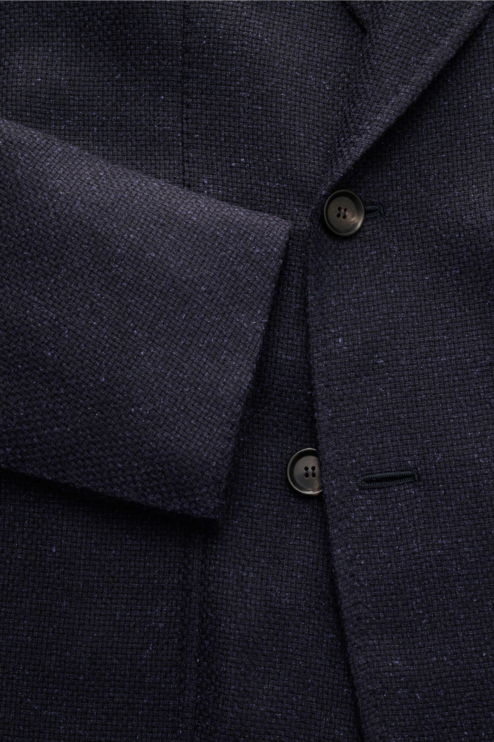 Close-up front view of the Stile Latino Smart-casual jacket 'Andrea' dark navy, showing textured fabric, two buttons, and sleeve cuff detail.

An eye for detail and an impeccable finish is what we have come to expect from the Neapolitan artisans, and t