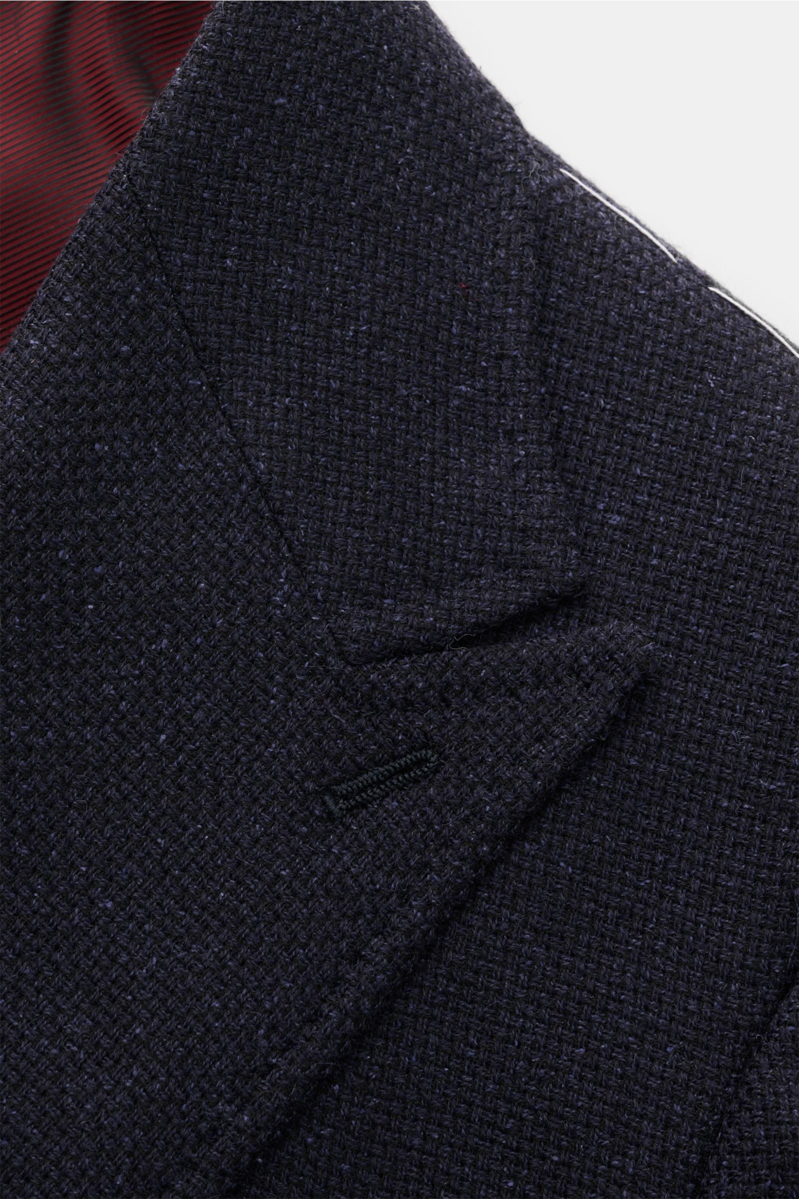 Close-up top-down view of the textured dark navy Stile Latino Smart-casual jacket 'Andrea' with pointed lapels and fine stitching.

An eye for detail and an impeccable finish is what we have come to expect from the Neapolitan artisans, and the exclusiv