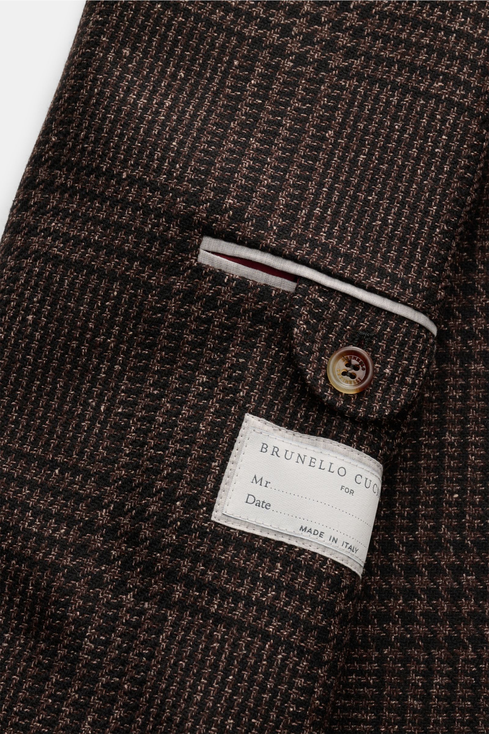 Nahaufnahme des Innenfutters eines Brunello Cucinelli Sakko schwarz/braun kariert mit tonalem Glencheck, weichem Griff, Slim Fit, drei Innentaschen, goldfarbenen Logo-Knöpfen und halb gefüttert, fotografiert aus schräger Perspektive.