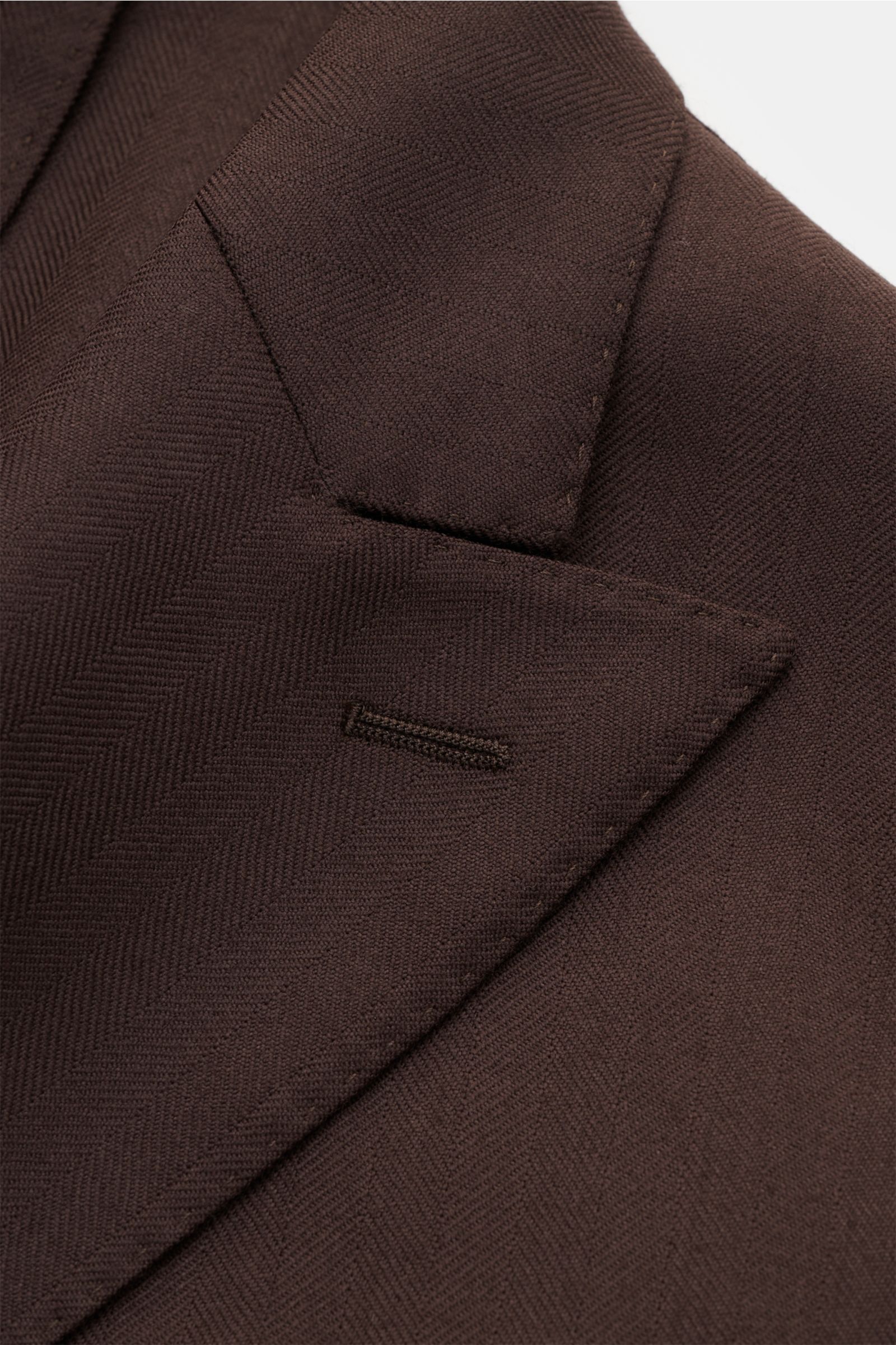 Close-up front angle of the Boglioli Sakko 'K. Jacket' dunkelbraun showing pure wool tonal herringbone fabric, slim fit, two-button three-button style, peaked lapel, classic breast pocket, patch hip pockets, kissing buttons, rear side vents, unconstructed