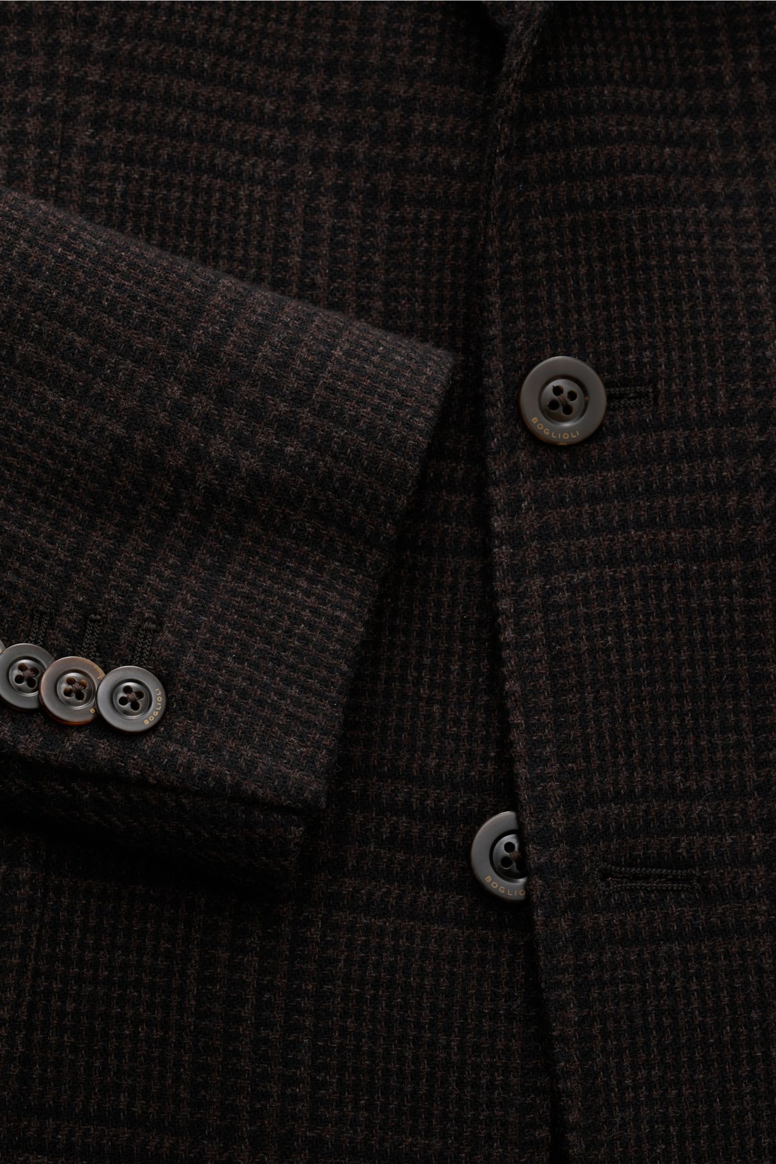 Close-up front view of Boglioli Sakko 'K. Jacket' dunkelbraun/schwarz kariert showing wool-cashmere slim fit jacket with Glencheck pattern, soft texture, two-button style, Kissing Buttons, and tailored details.

Wenn italienische Nonchalance auf feine 