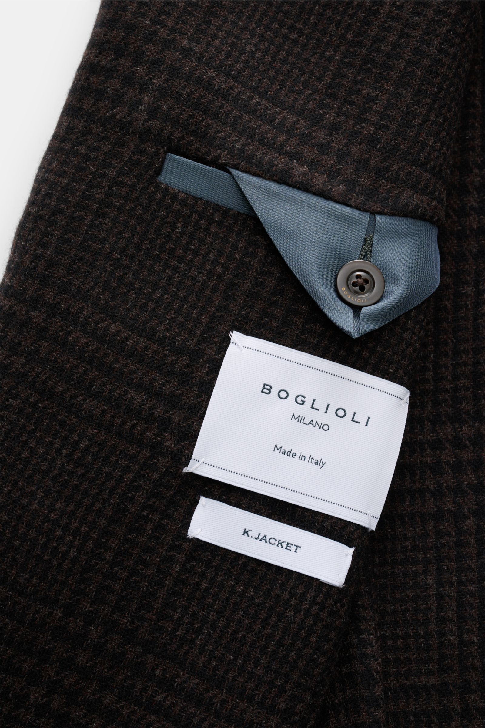 Close-up view of the inner pocket and label of the Boglioli Sakko 'K. Jacket' dunkelbraun/schwarz kariert showing wool-cashmere fabric, button, and lining. When Italian nonchalance meets fine tailoring, the 'K. Jacket' from BOGLIOLI offers an unconstructe