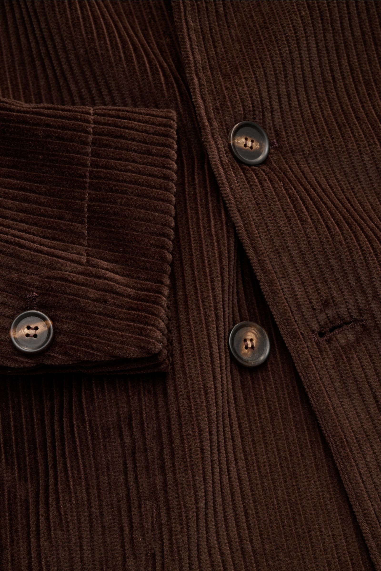 Nahaufnahme des dunkelbraunen Doppiaa Cord-Sakkos 'Aansonia' aus Baumwoll-Cord, Slim Fit, zweireihiger Drei-Knopf-Stil, Spitzrevers, aufgesetzte Hüfttaschen, Ärmelabschluss mit verdecktem Knopf, rückwärtige Seitenschlitze und eine Innentasche, frontal fot