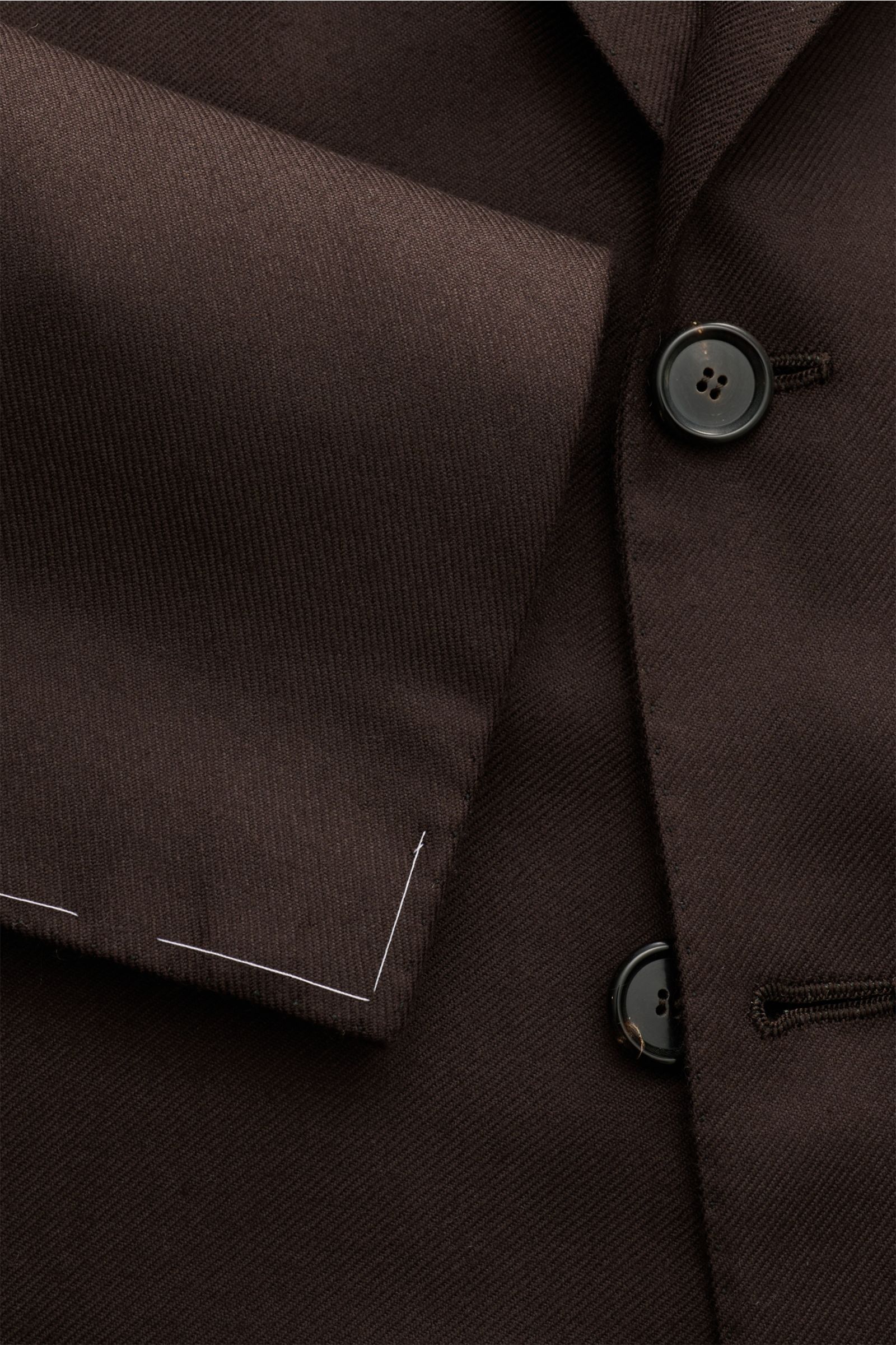 Nahaufnahme von dunkelbraunem Cesare Attolini Cashmere Sakko mit tailliertem Drei-Knopf-Stil, fallendem Revers, Brust- und Hüfttaschen, unfertigen Ärmelabschlüssen, halb gefüttert und seitlichen Rückenschlitzen.