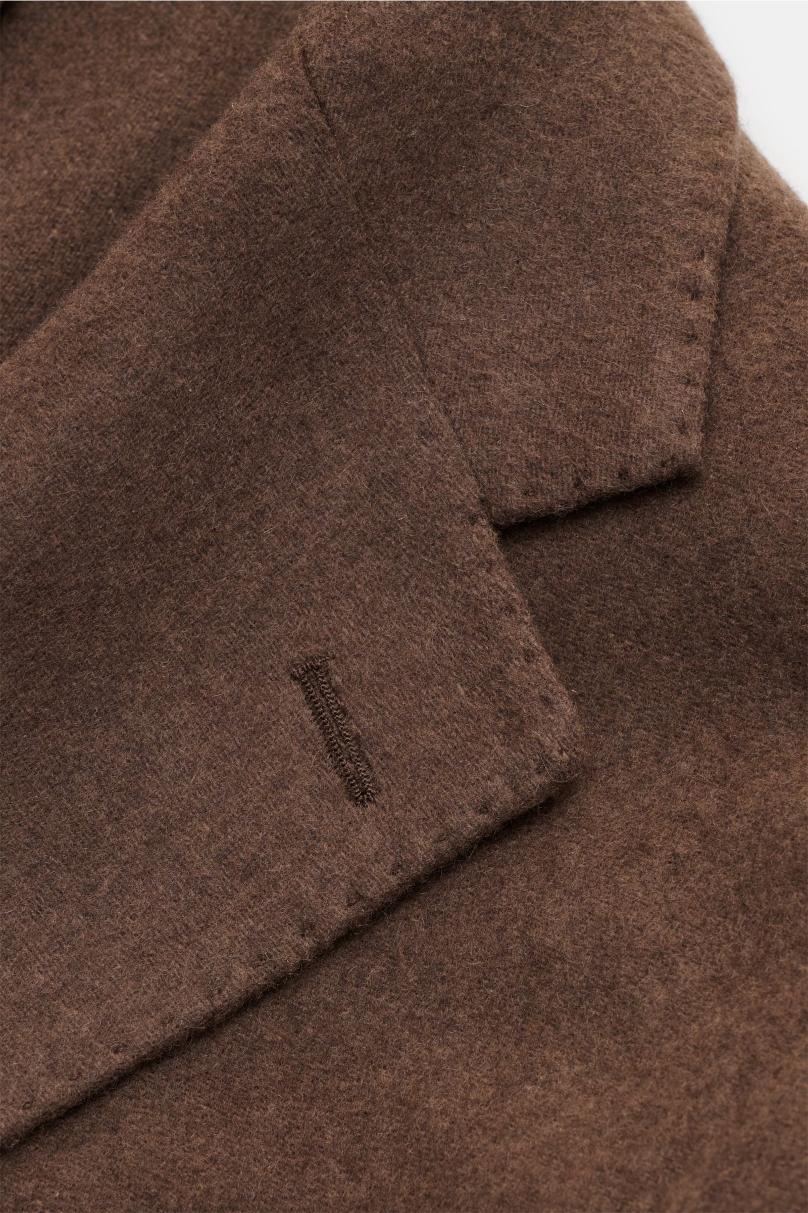 Close-up view of the graubraun collar and buttonhole of the Windsor Cashmere Sakko 'Giorno' showing its soft, elastic cashmere fabric and fine stitching. Luxuriöse Leichtigkeit für den Business-Alltag: Das Cashmere Sakko von WINDSOR vereint edle Materiali